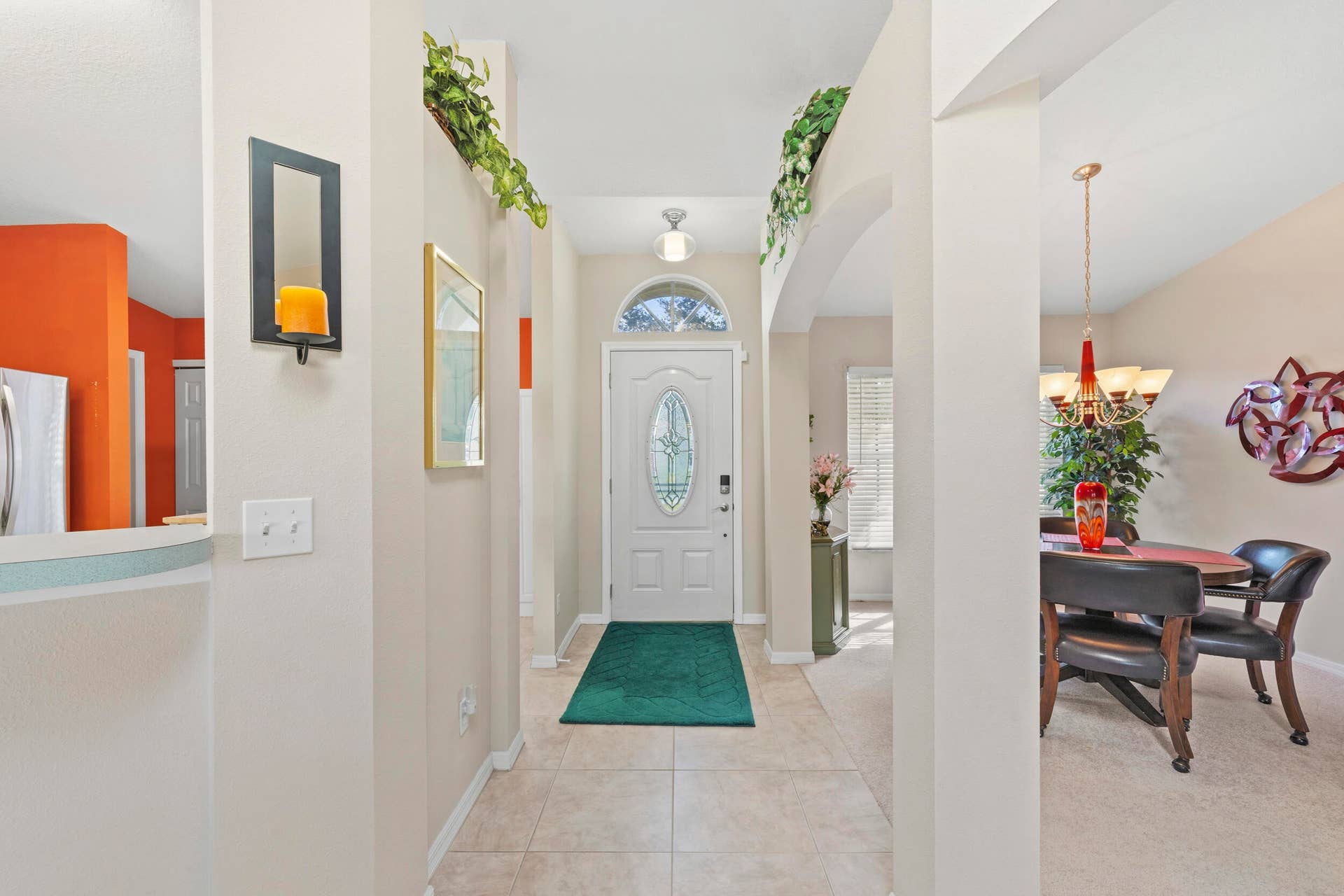 1649 SW ALVATON Avenue, Port St Lucie, FL 34953 Entryway featuring ceramic tile flooring, arched wall cutouts, a six-panel front door with an oval glass insert, and a transom window