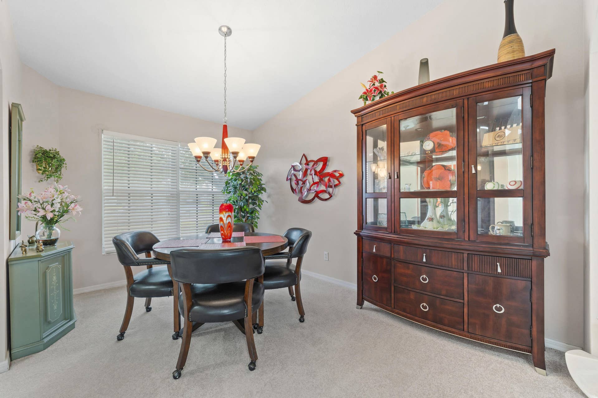 1649 SW ALVATON Avenue, Port St Lucie, FL 34953 Vaulted ceiling, multi-light hanging chandelier, and horizontal blind window treatments
