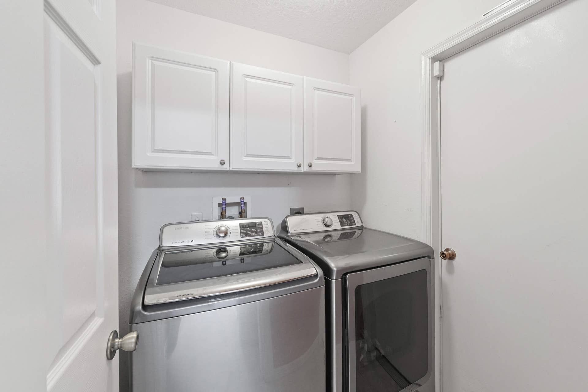 1649 SW ALVATON Avenue, Port St Lucie, FL 34953 Laundry area featuring crisp white shaker-style cabinetry and dedicated washer and dryer hookups