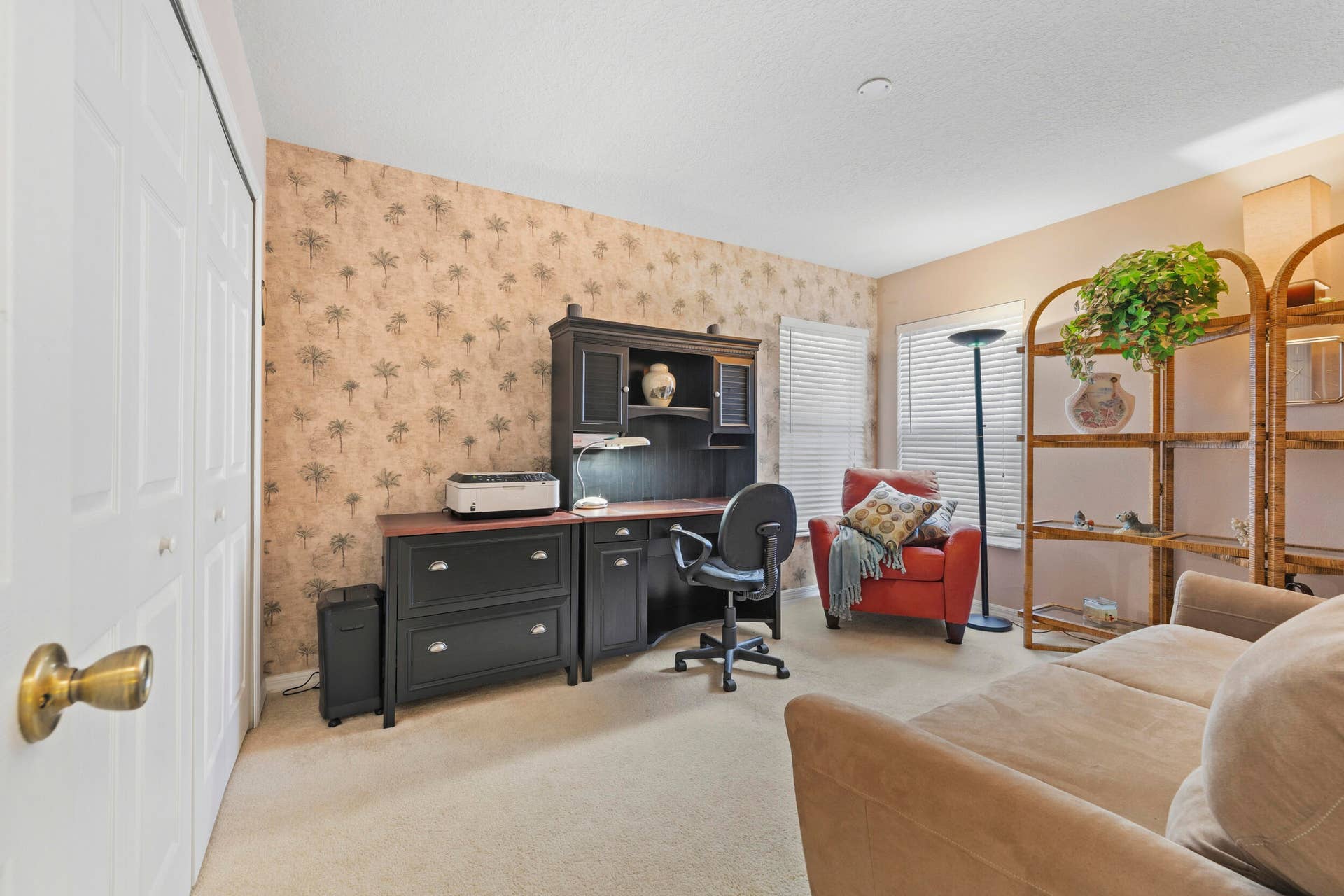 1649 SW ALVATON Avenue, Port St Lucie, FL 34953 Room featuring neutral wall-to-wall carpeting, dual-door closet with polished brass hardware, and accent wallpaper