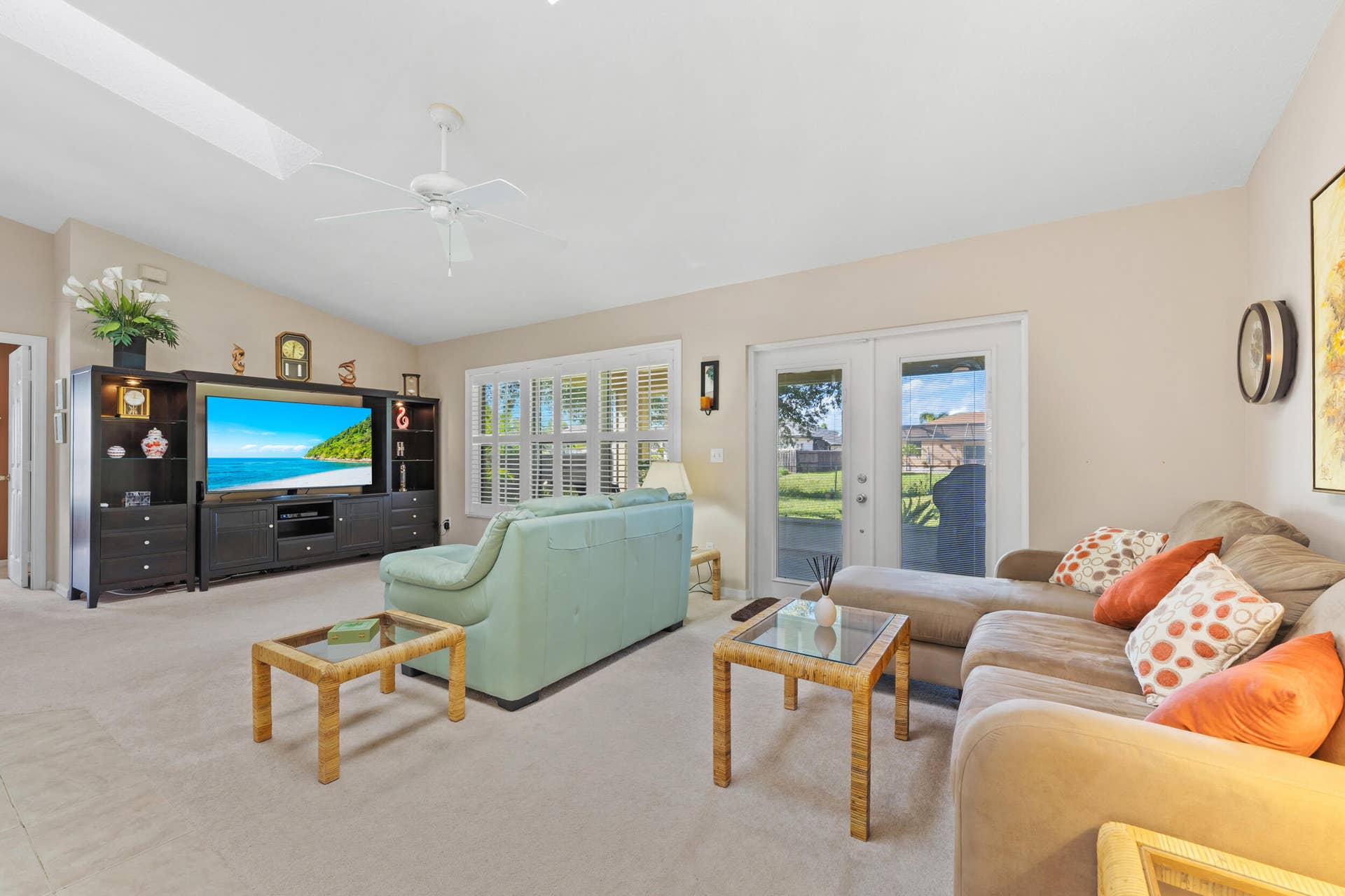 1649 SW ALVATON Avenue, Port St Lucie, FL 34953 Vaulted ceiling with integrated ceiling fan, built-in cabinetry, dual-pane windows with plantation shutters, and glass-paneled french doors