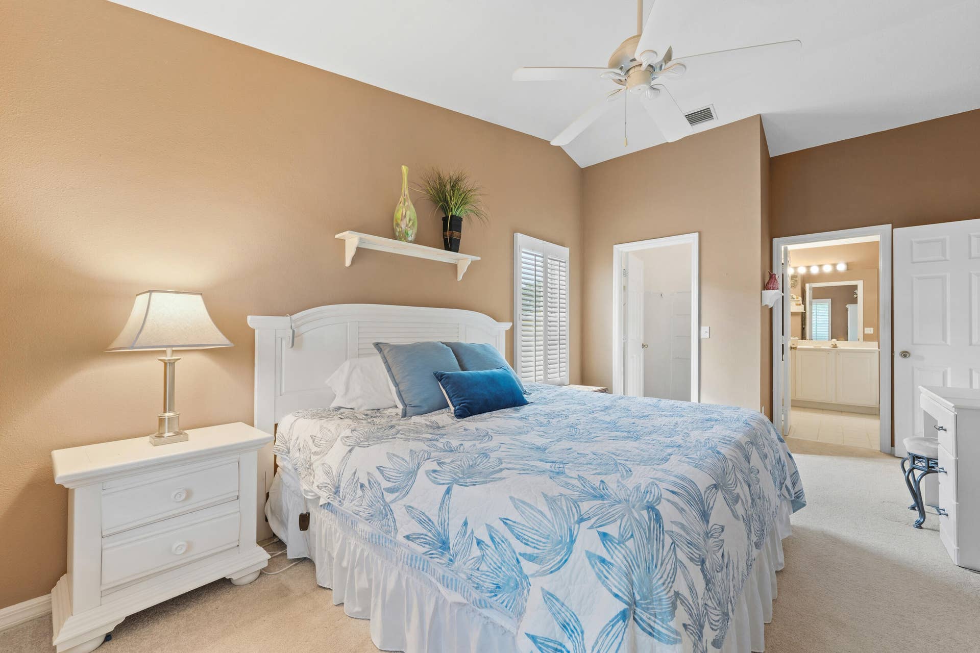 1649 SW ALVATON Avenue, Port St Lucie, FL 34953 Vaulted ceiling with a white overhead fan, wall-mounted display shelf, carpeted flooring, and white plantation shutters