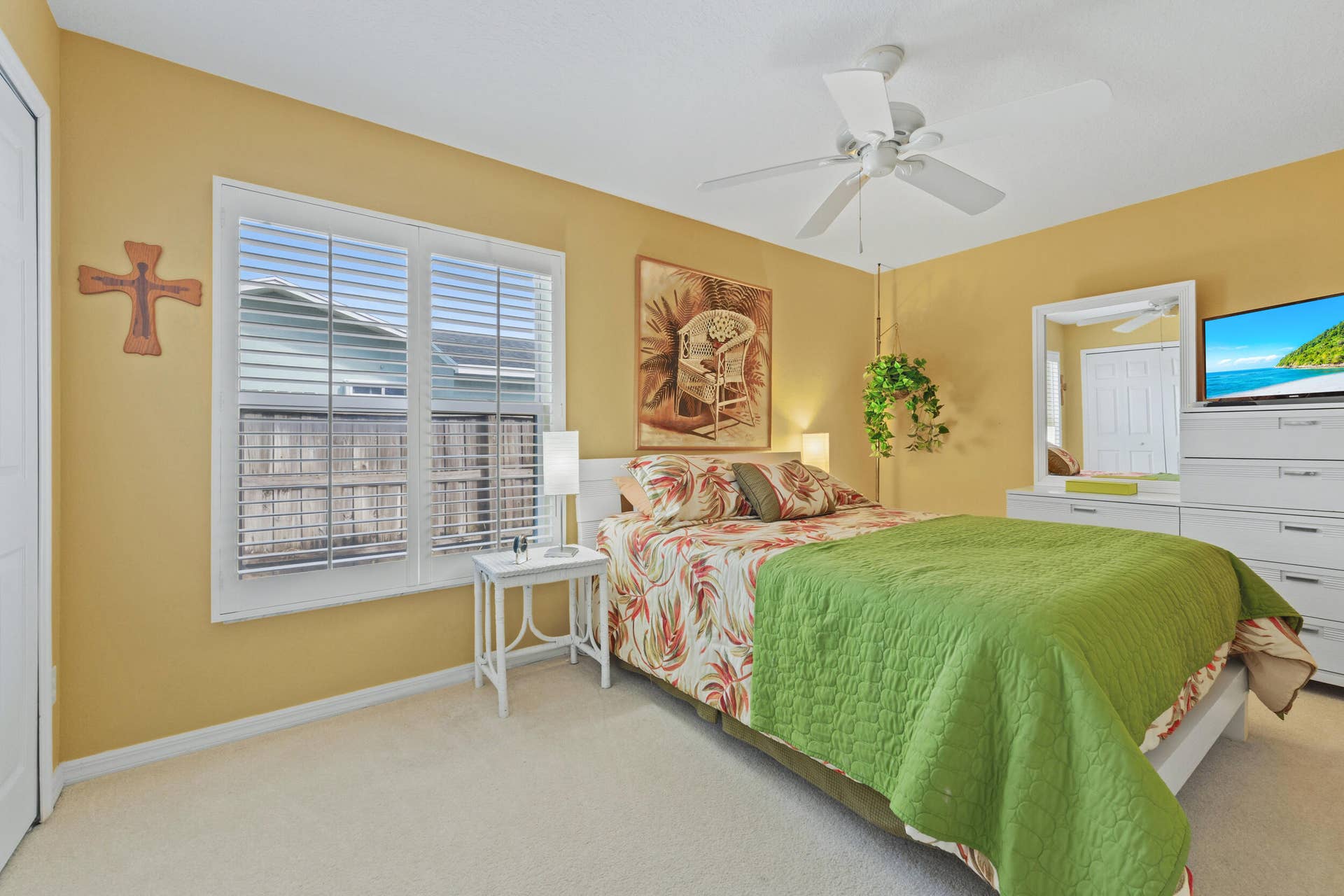 1649 SW ALVATON Avenue, Port St Lucie, FL 34953 Bedroom featuring white plantation shutters, neutral carpeting, and a white ceiling fan with integrated lighting
