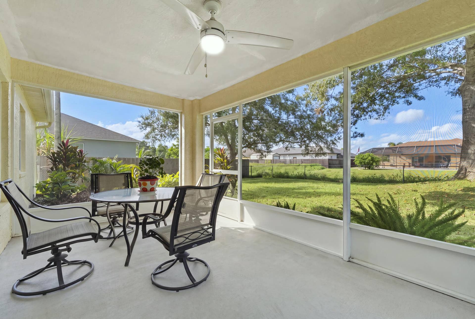 1649 SW ALVATON Avenue, Port St Lucie, FL 34953 Screened-in porch featuring a concrete floor, ceiling fan with integrated lighting, and expansive mesh enclosures