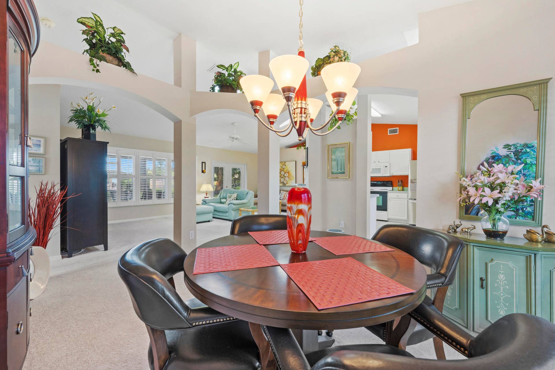 1649 SW ALVATON Avenue, Port St Lucie, FL 34953 Dining area featuring arched entryways, vaulted ceilings, integrated plant ledges, and a multi-arm pendant light fixture