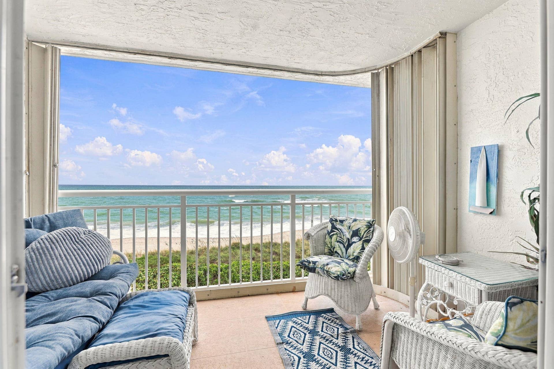 Balcony with a metal railing, concrete flooring, and accordion hurricane shutters