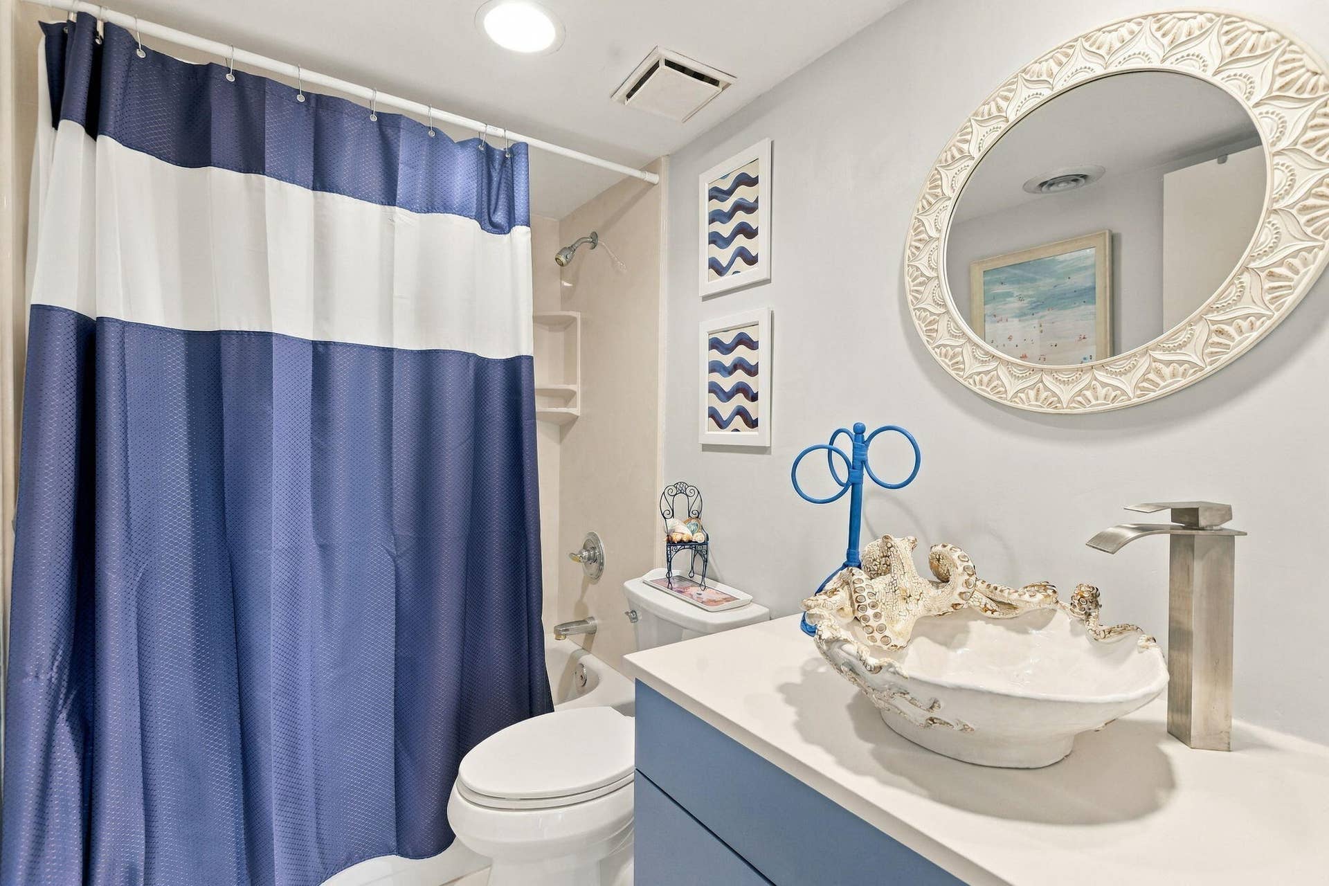 White vanity with a vessel sink and contemporary faucet