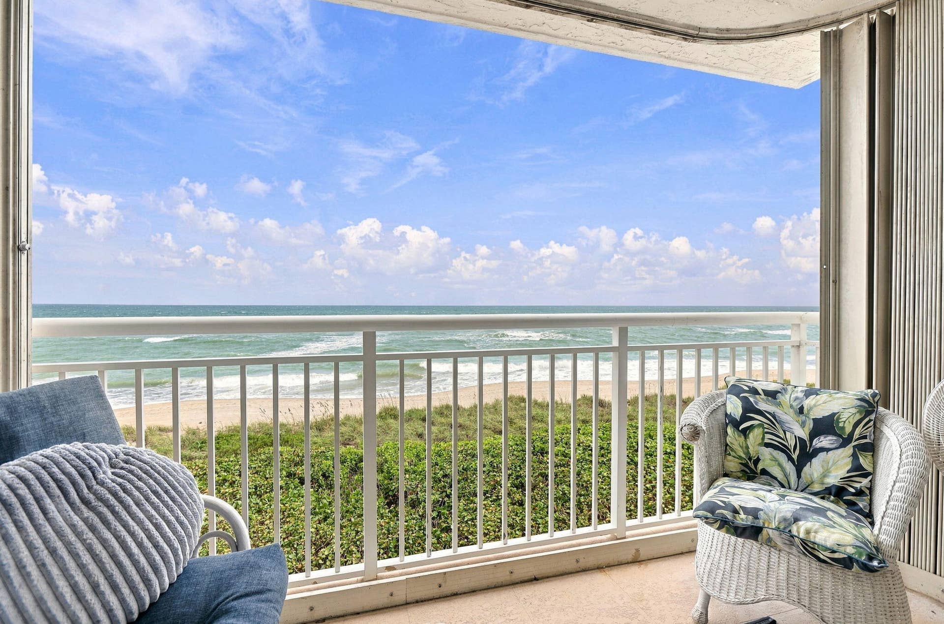 Balcony with full ocean scenery and white railing