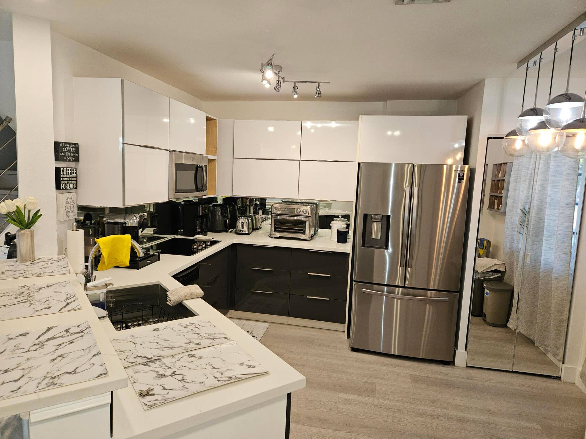 1460 SW 47TH Avenue, #1460, Deerfield Beach, Deerfield Beach, FL 33442 Contemporary kitchen featuring white upper cabinetry, dark lower cabinetry, stainless steel appliances, and a track lighting fixture
