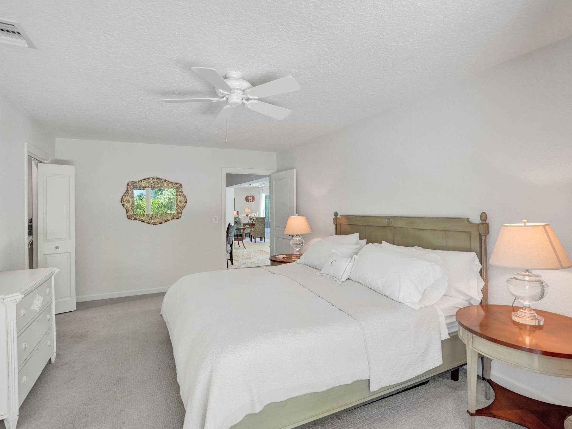Serene setting with Ceiling fan, and light colored carpeting.