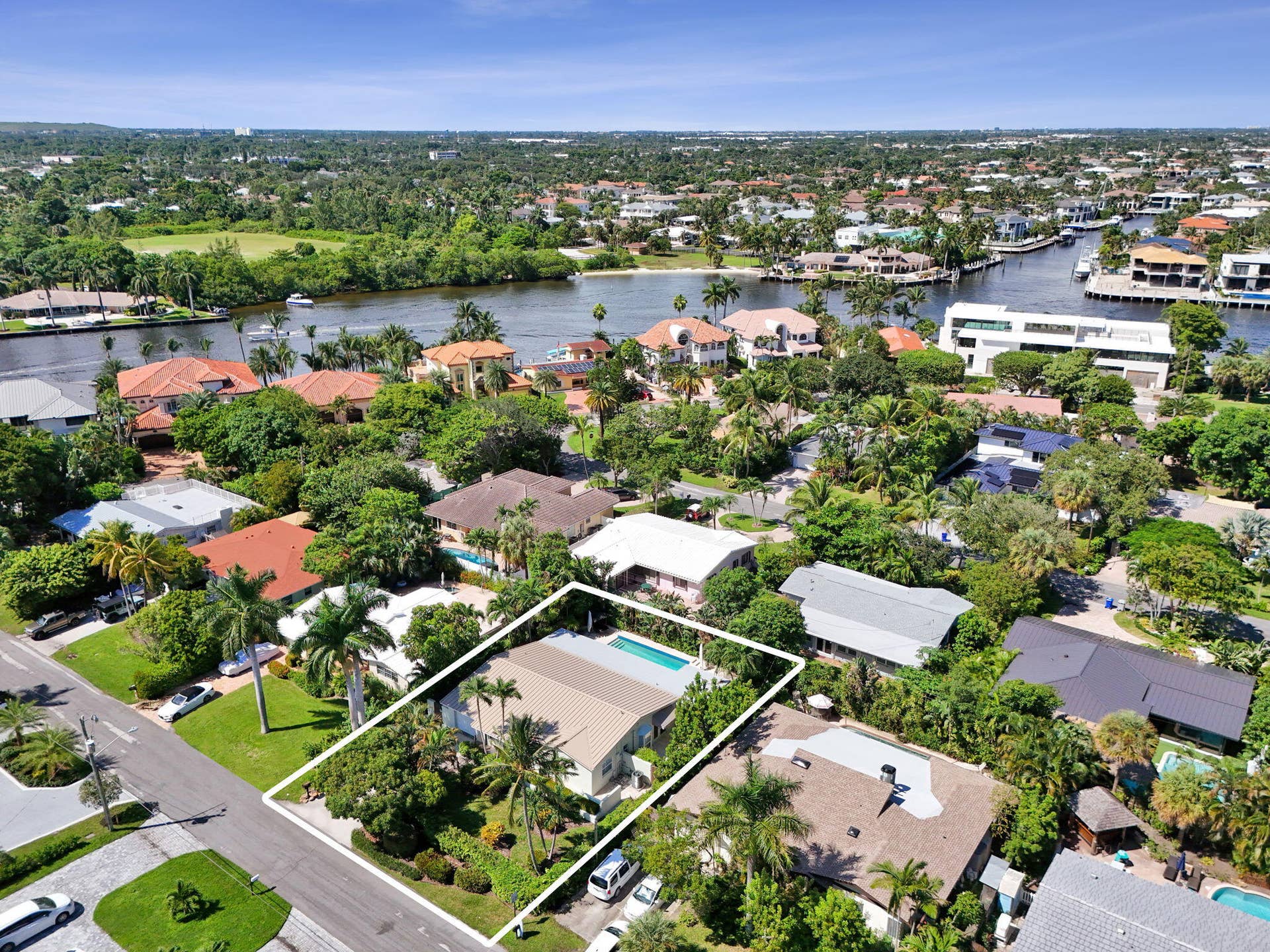 Aerial perspective showcasing a residential property with an outdoor swimming pool, surrounded by mature landscaping