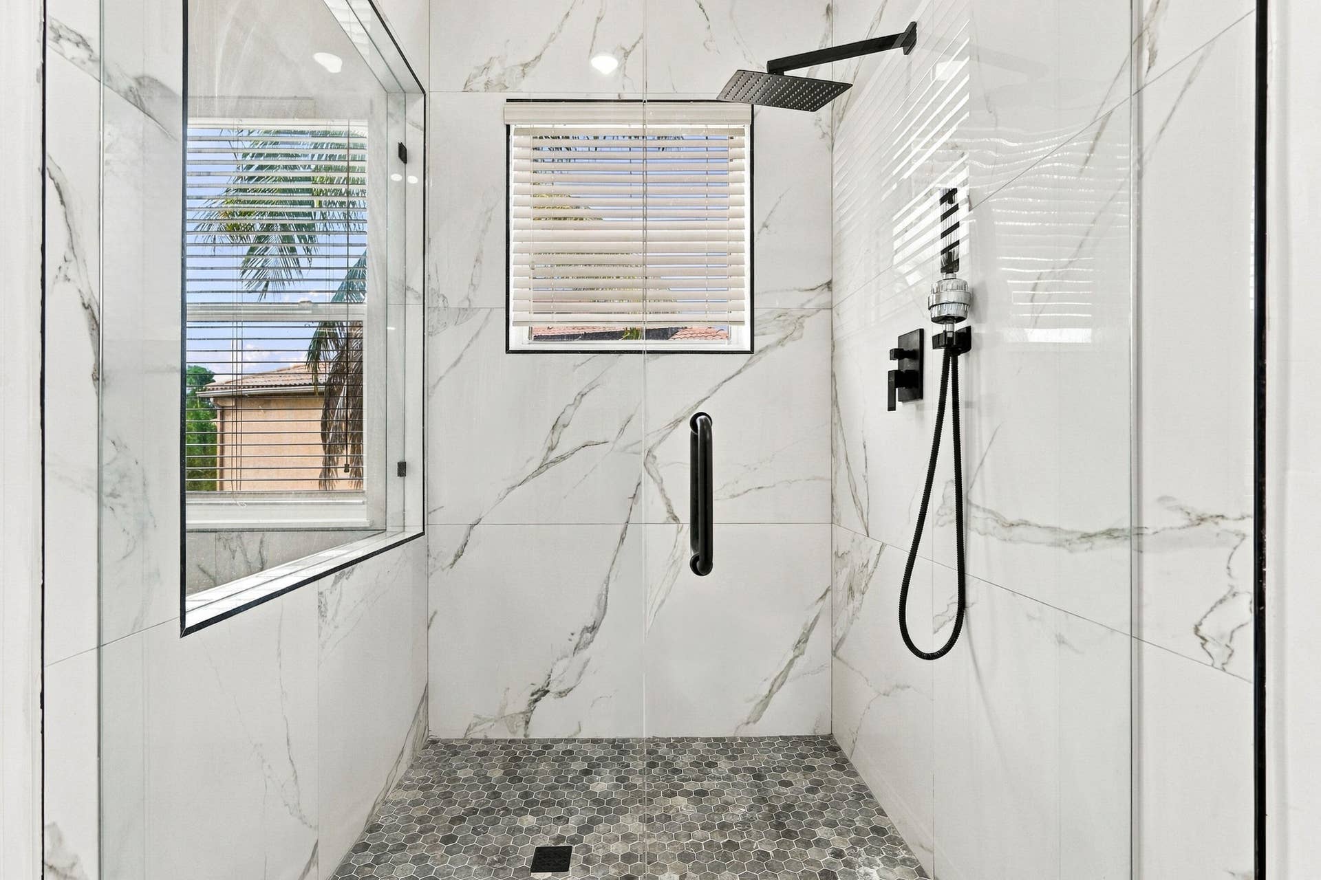 Primary Bedroom has fully updated shower with marble tiles.