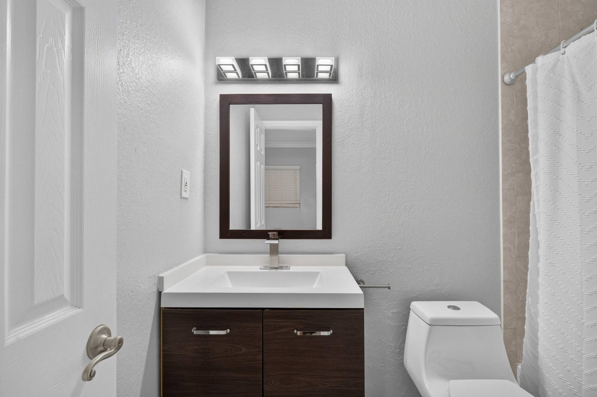 744 NE 14th Avenue, #21, Fort Lauderdale, FL 33304 Modern vanity with dark wood-finish cabinetry, white countertop, and integrated sink