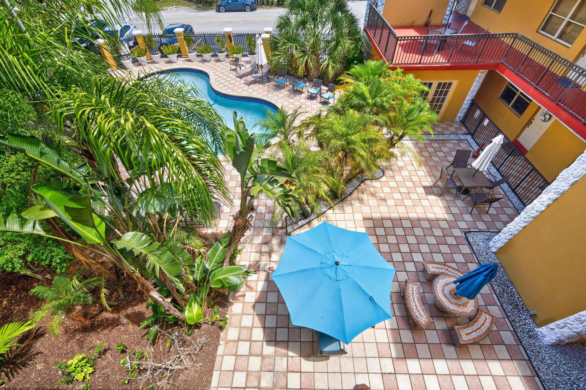 744 NE 14th Avenue, #21, Fort Lauderdale, FL 33304 Courtyard featuring a freeform swimming pool, paved patio, mature tropical landscaping, and second-story balcony