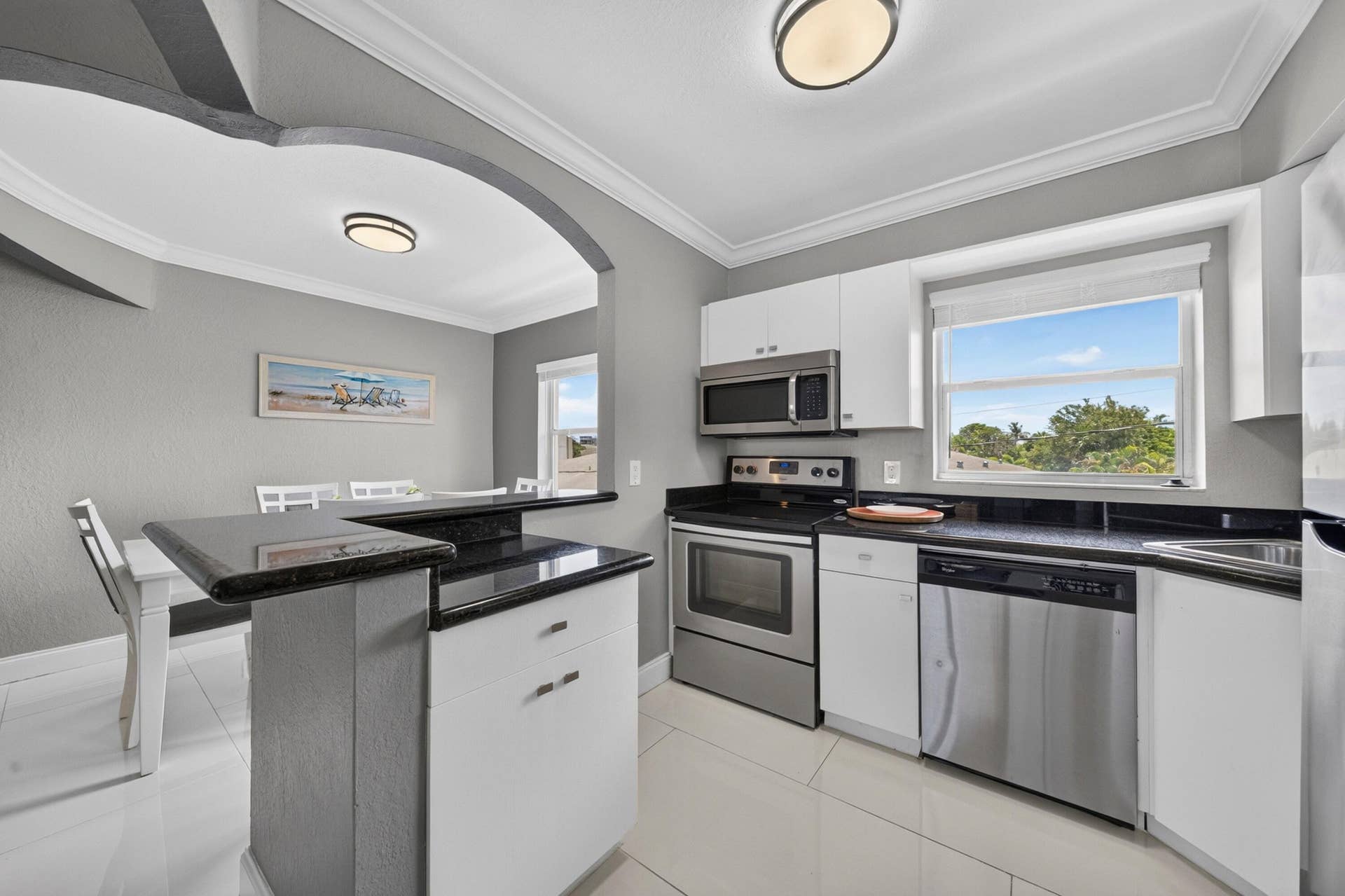 744 NE 14th Avenue, #21, Fort Lauderdale, FL 33304 Kitchen featuring stainless steel appliances, solid surface countertops, white cabinetry, and tile flooring