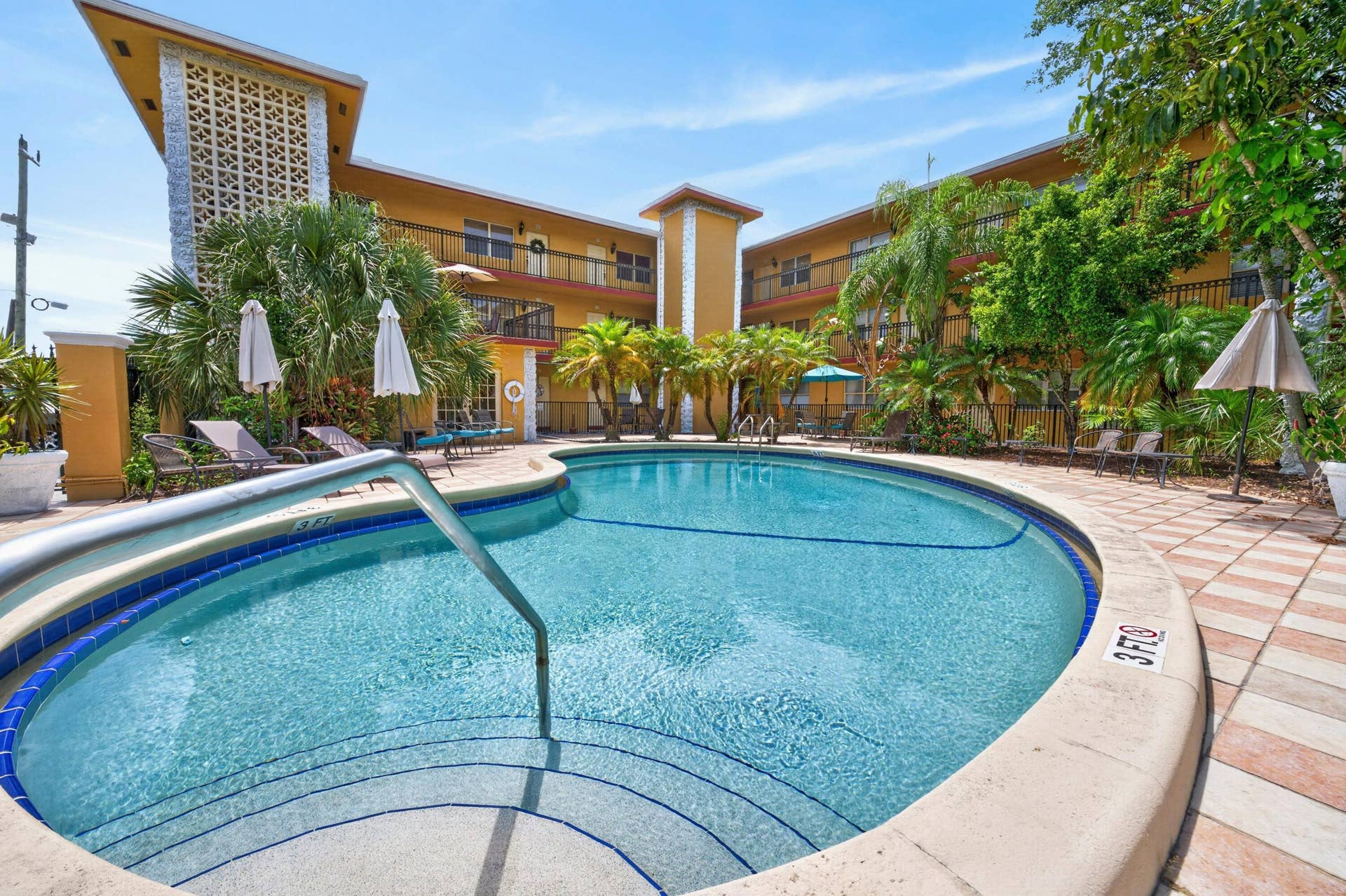 744 NE 14th Avenue, #21, Fort Lauderdale, FL 33304 Resort-style pool area featuring a curved swimming pool, integrated spa, and tiled surround