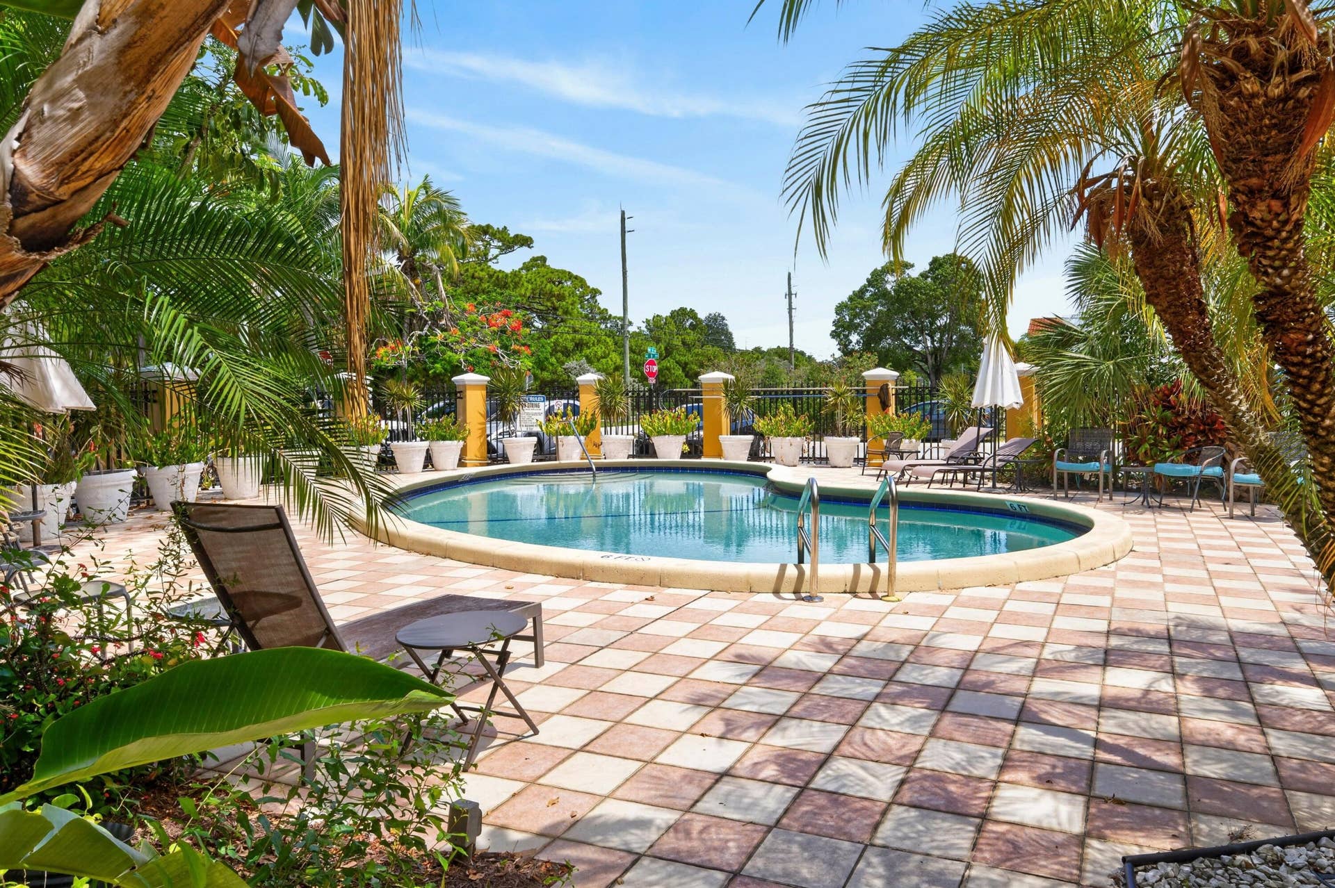 744 NE 14th Avenue, #21, Fort Lauderdale, FL 33304 Oval swimming pool with a stone coping, surrounded by a checkered paver patio