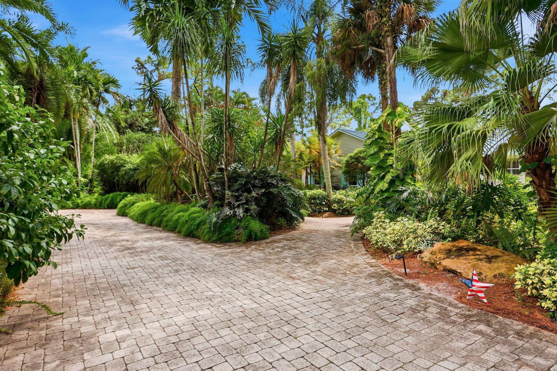 Circular driveway with lush landscaping makes the house feel like a secret garden