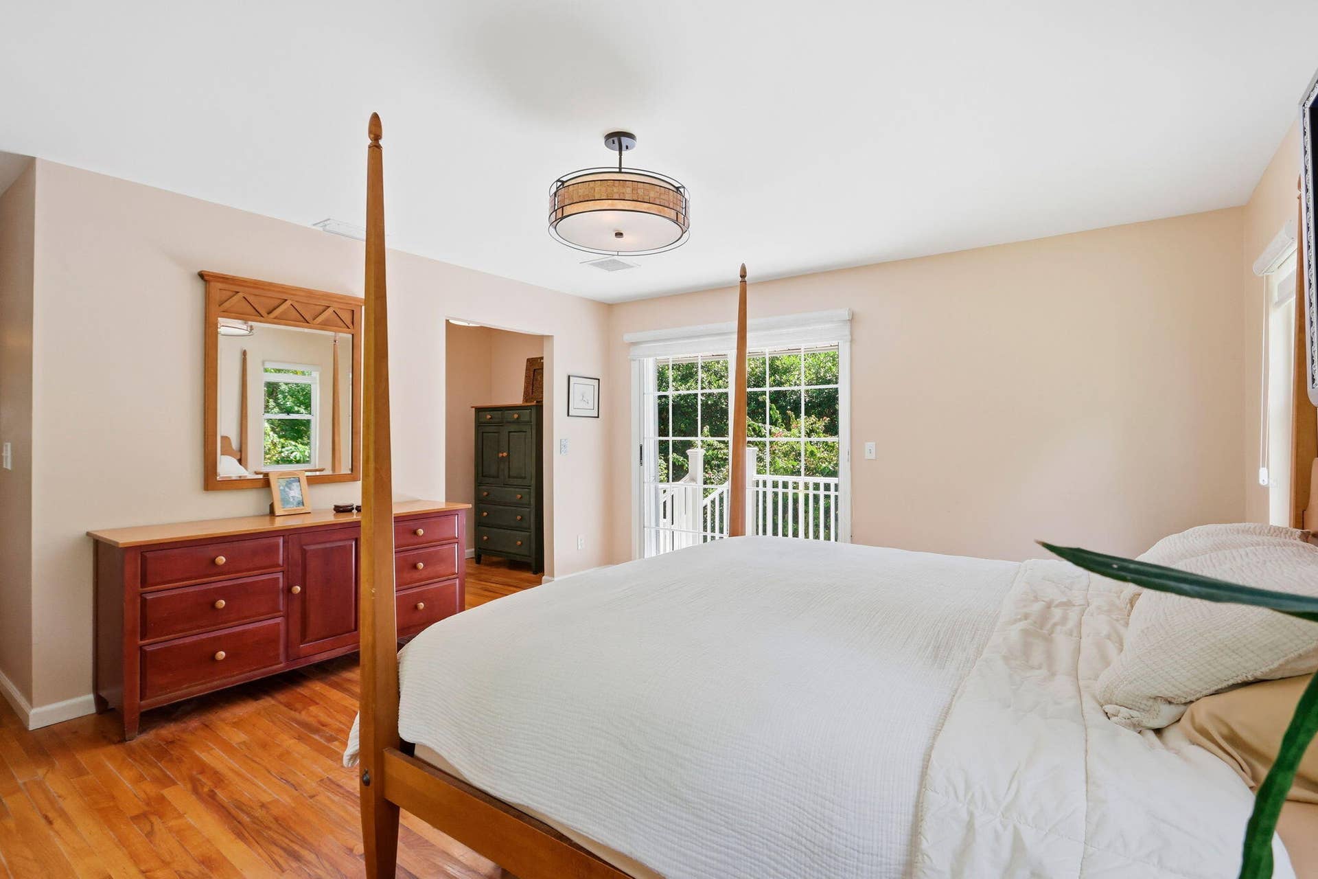 Wood-finish flooring, overhead drum pendant lighting, and sliding glass doors with balcony access