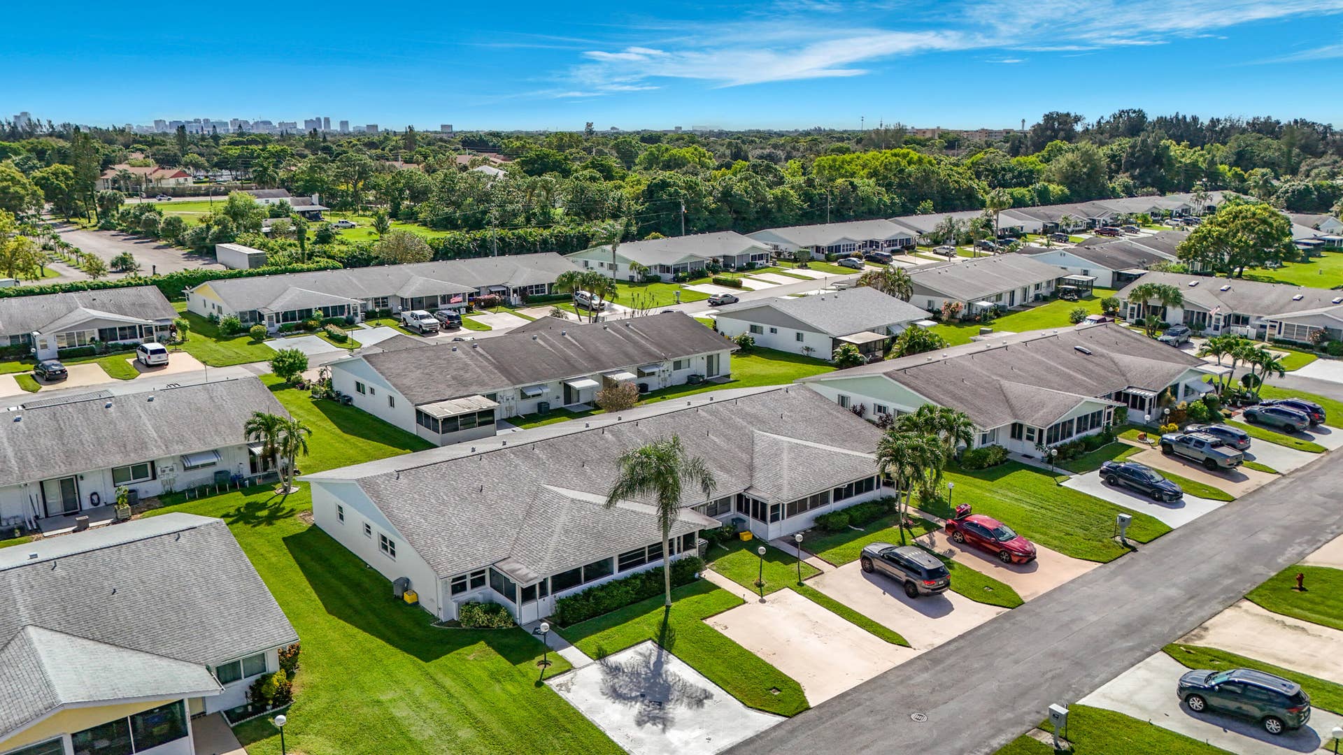 Row of single-story residences with paved driveways and screened porches