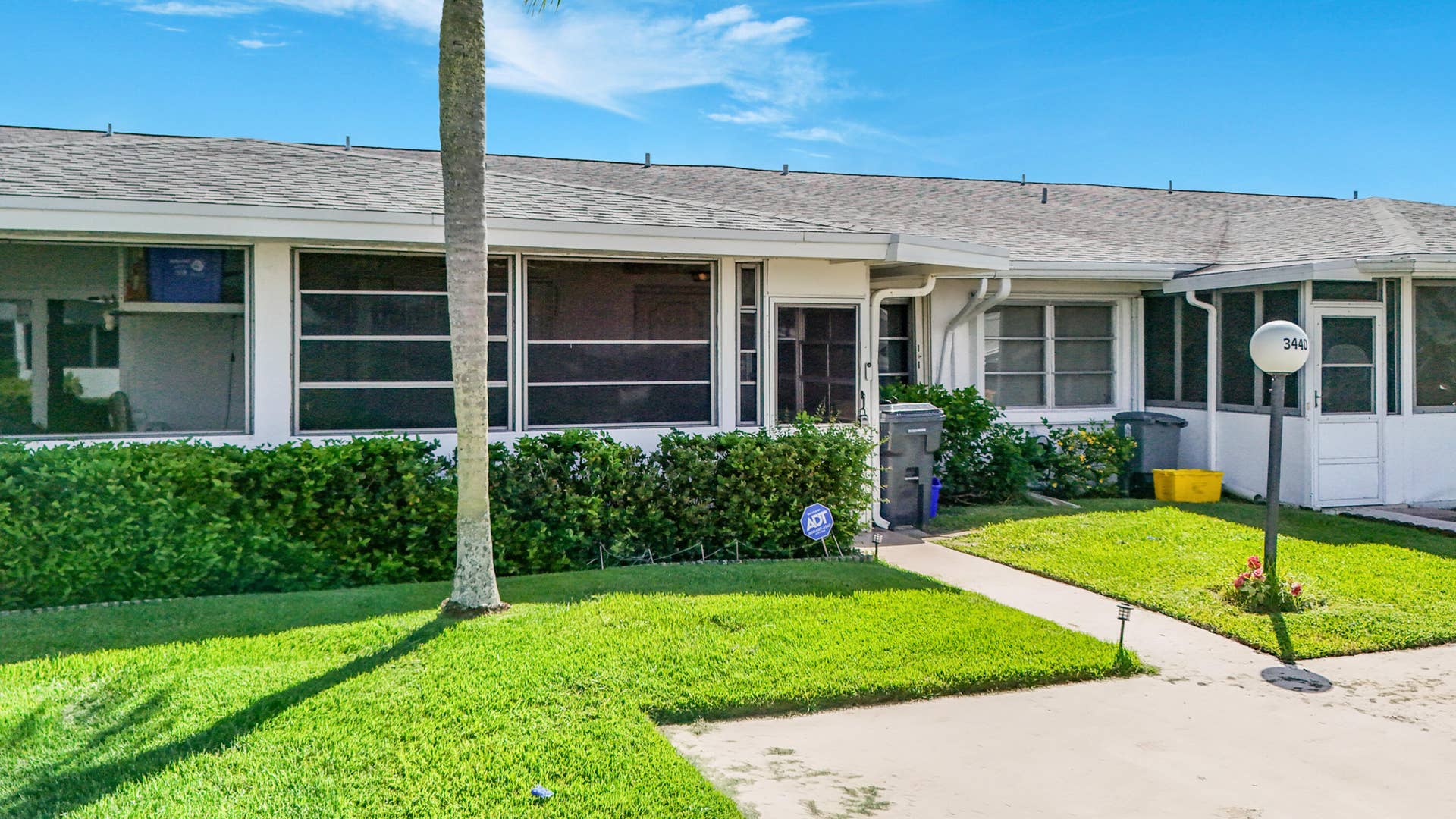 Screened windows, mature landscaping, sidewalk access, and a screened outdoor area