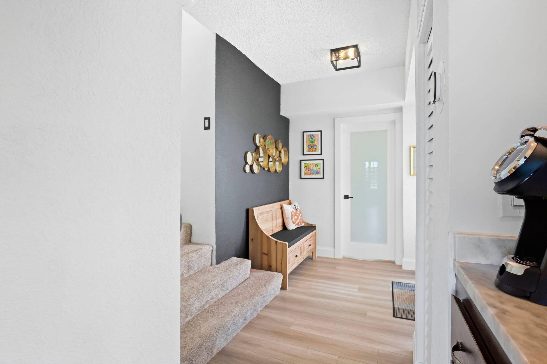 900 Greensward Lane, #209-G, Delray Beach, FL 33445 Wood-finish flooring with a contrasting accent wall, contemporary flush-mount lighting, and a frosted glass-paneled door