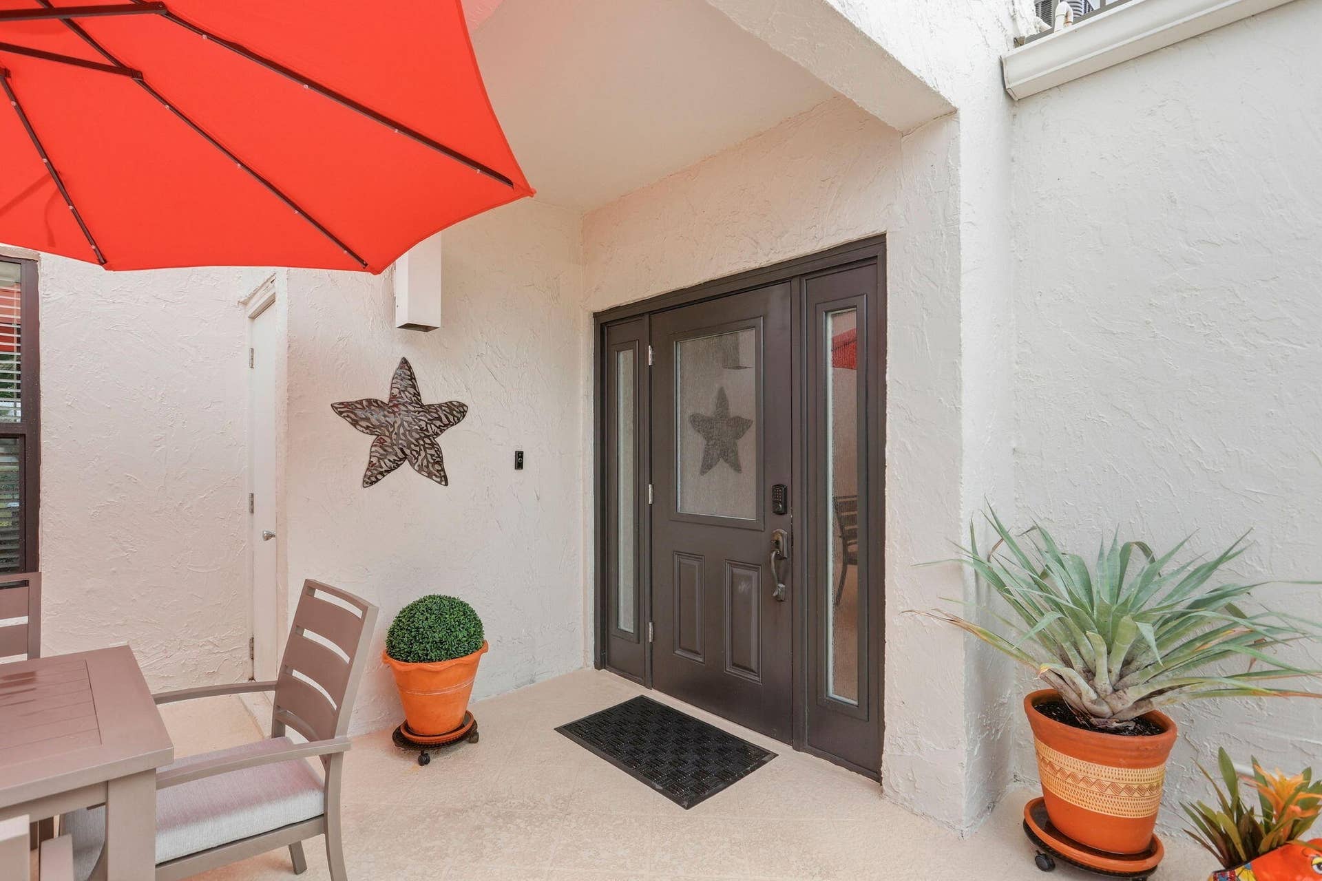 900 Greensward Lane, #209-G, Delray Beach, FL 33445 Double-door entry with decorative glass inserts, textured exterior wall finish, and a covered entry