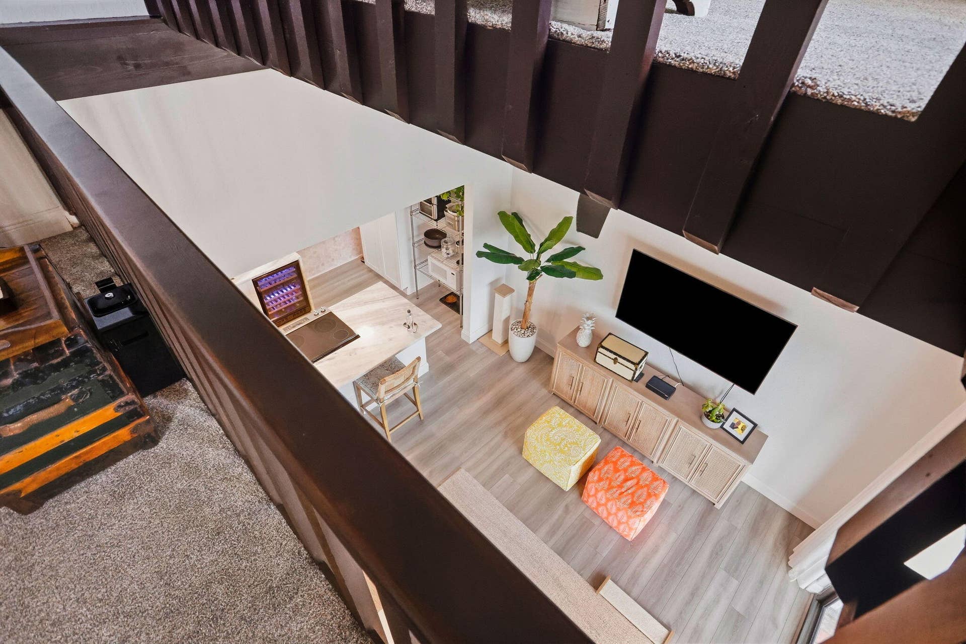 900 Greensward Lane, #209-G, Delray Beach, FL 33445 Open-concept living space with wood-finish flooring, built-in beverage refrigerator, and a built-in entertainment console
