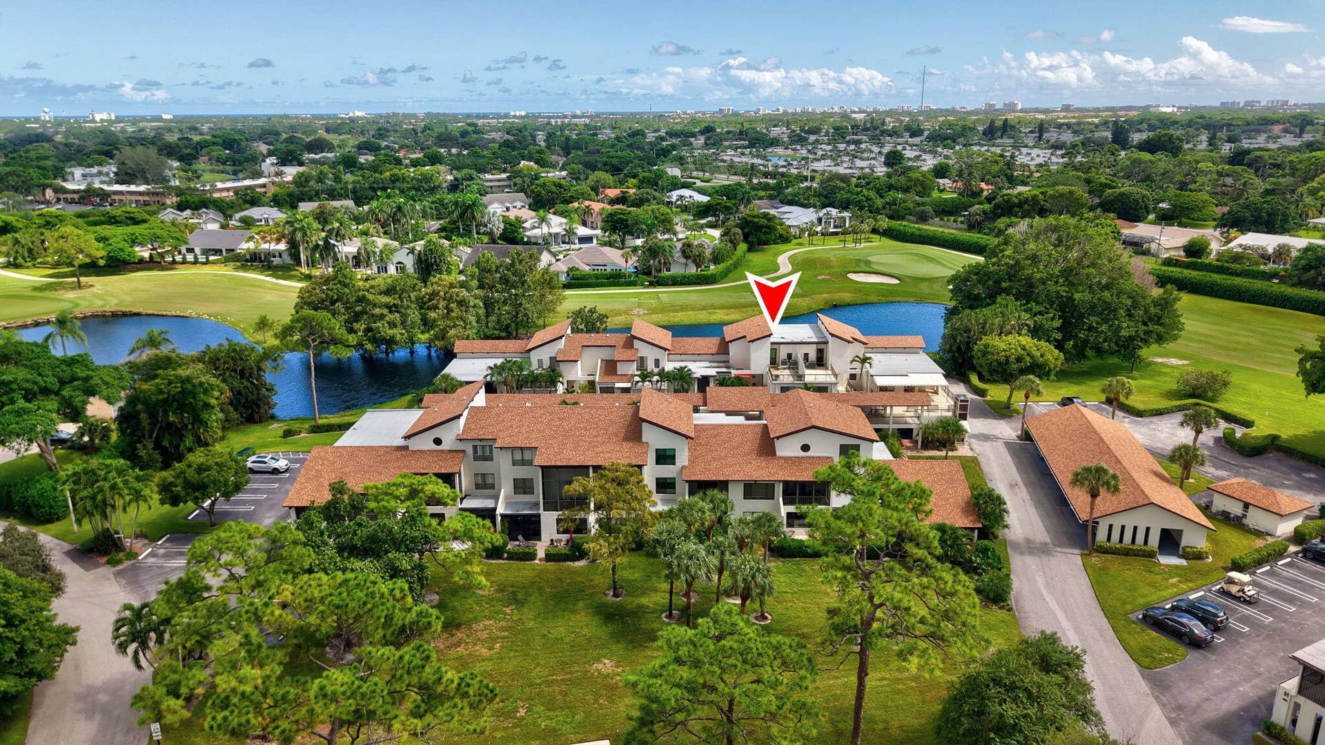 900 Greensward Lane, #209-G, Delray Beach, FL 33445 Multi-story residential complex with terraced balconies, surrounded by mature trees and manicured lawns