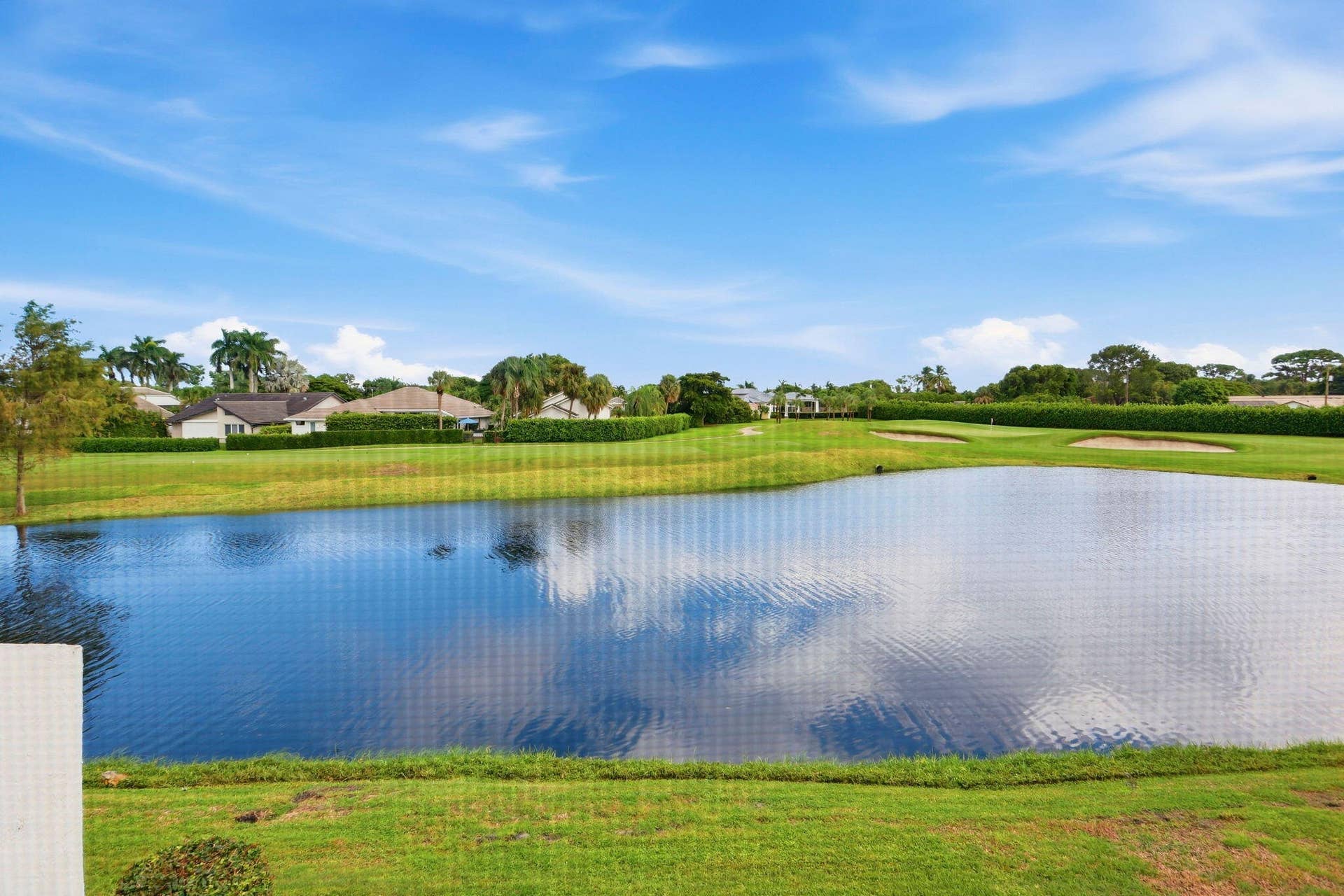 900 Greensward Lane, #209-G, Delray Beach, FL 33445 Expansive water feature with surrounding green space, mature landscaping, and golf course bunkers
