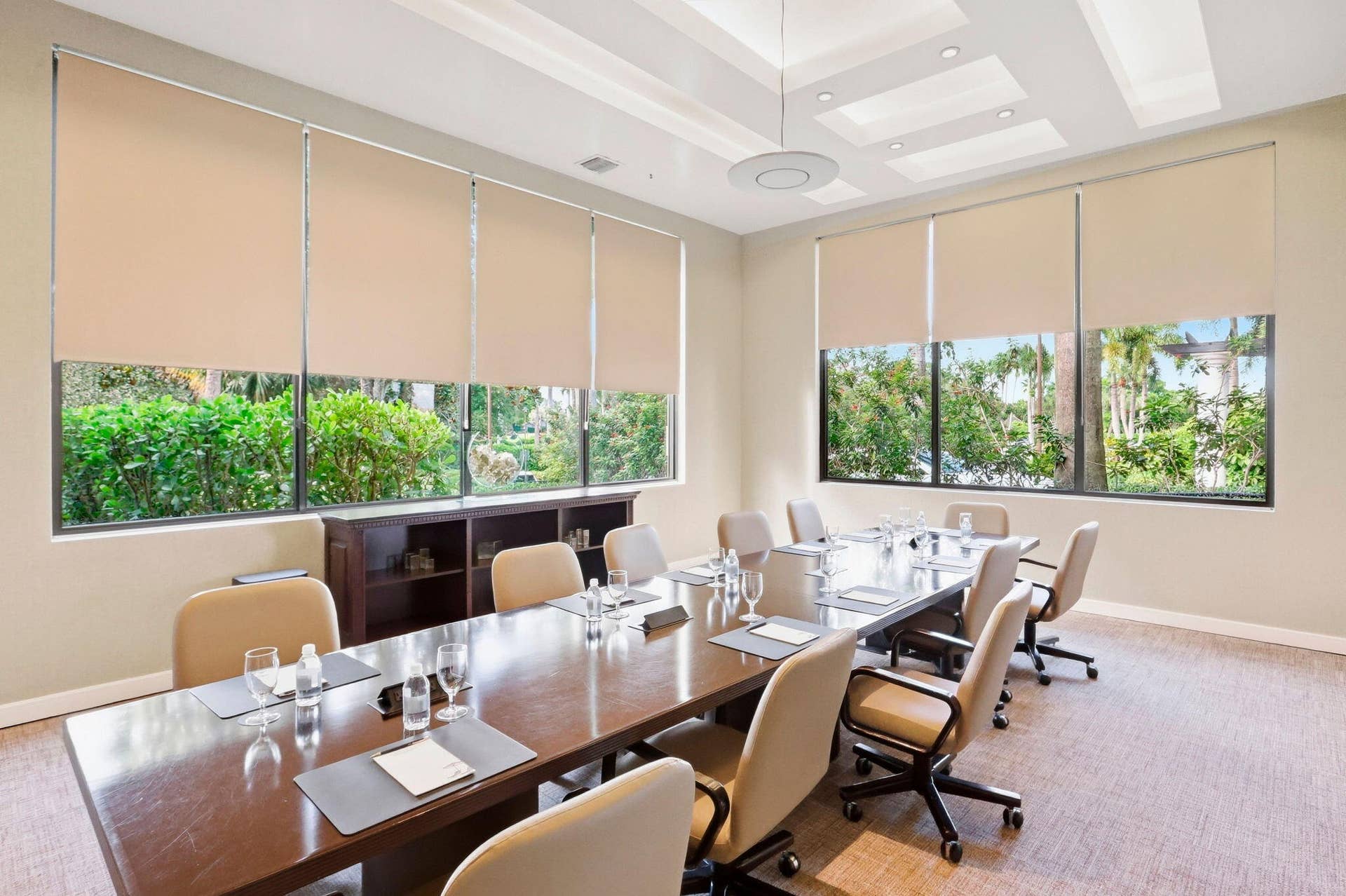 900 Greensward Lane, #209-G, Delray Beach, FL 33445 Recessed lighting, tray ceiling, large windows with roller shades, dark wood-finish conference table, and built-in cabinetry