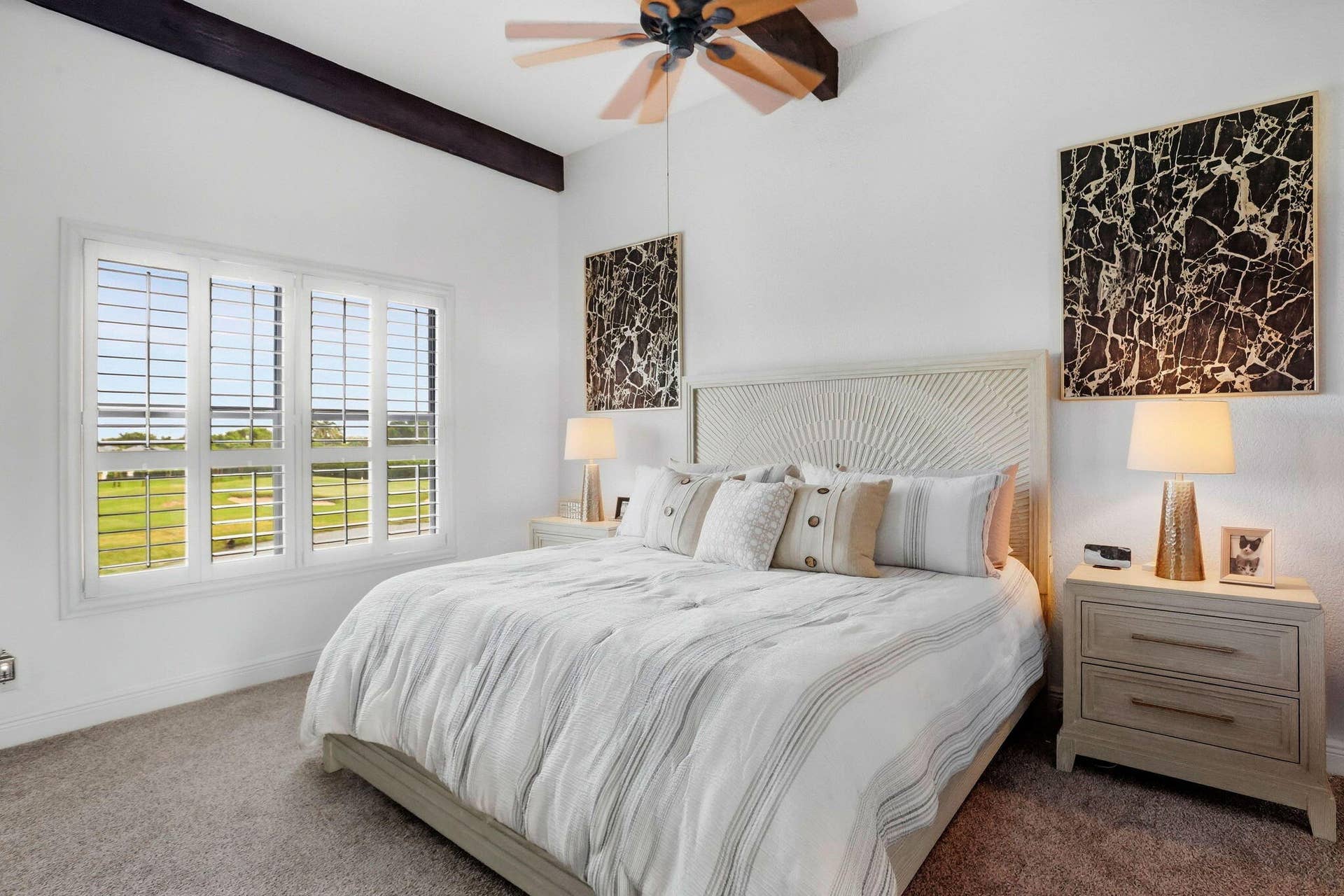 900 Greensward Lane, #209-G, Delray Beach, FL 33445 White interior walls with a dark wood beam accent, light-colored carpeting, and a multi-pane window with plantation shutters
