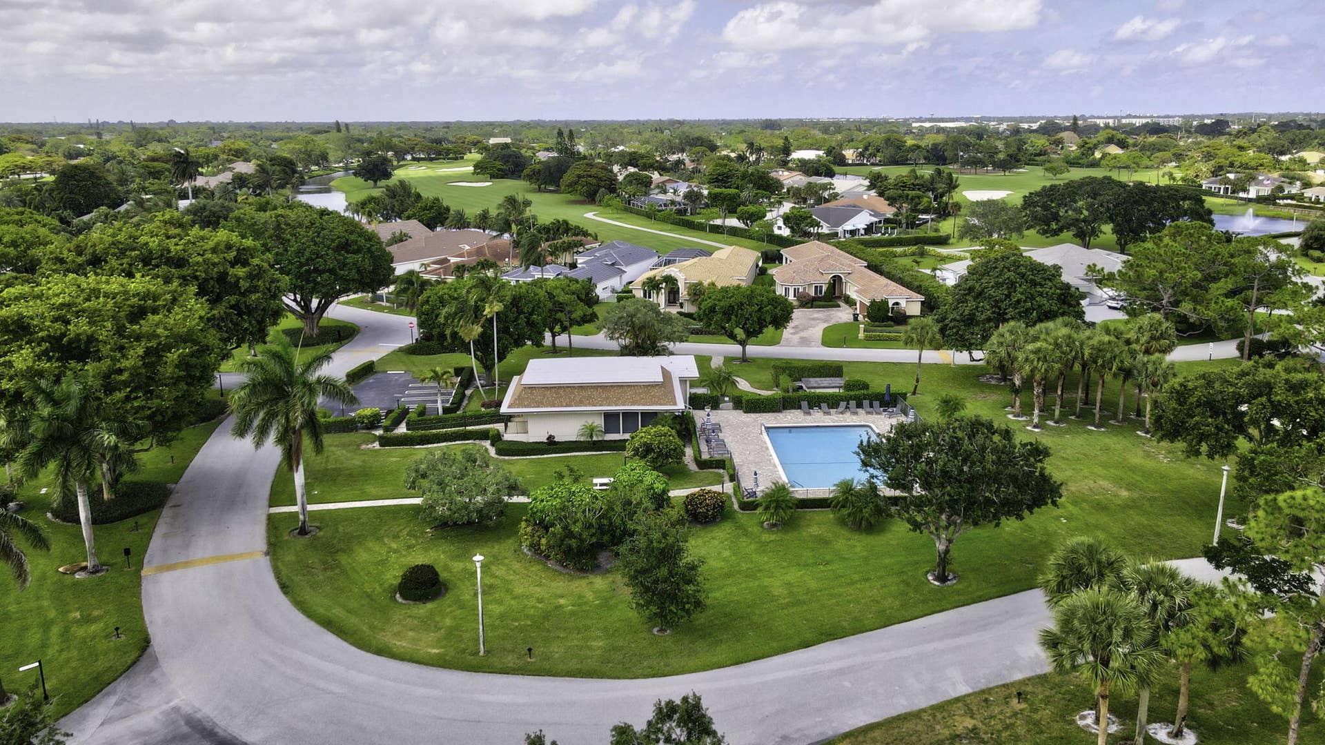 900 Greensward Lane, #209-G, Delray Beach, FL 33445 Lush landscaping with mature trees, expansive green spaces, and paved roadways
