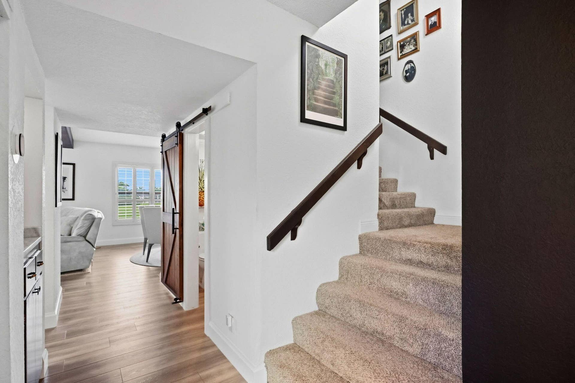 900 Greensward Lane, #209-G, Delray Beach, FL 33445 Wood-finish flooring, white walls, and a wood barn door with black hardware