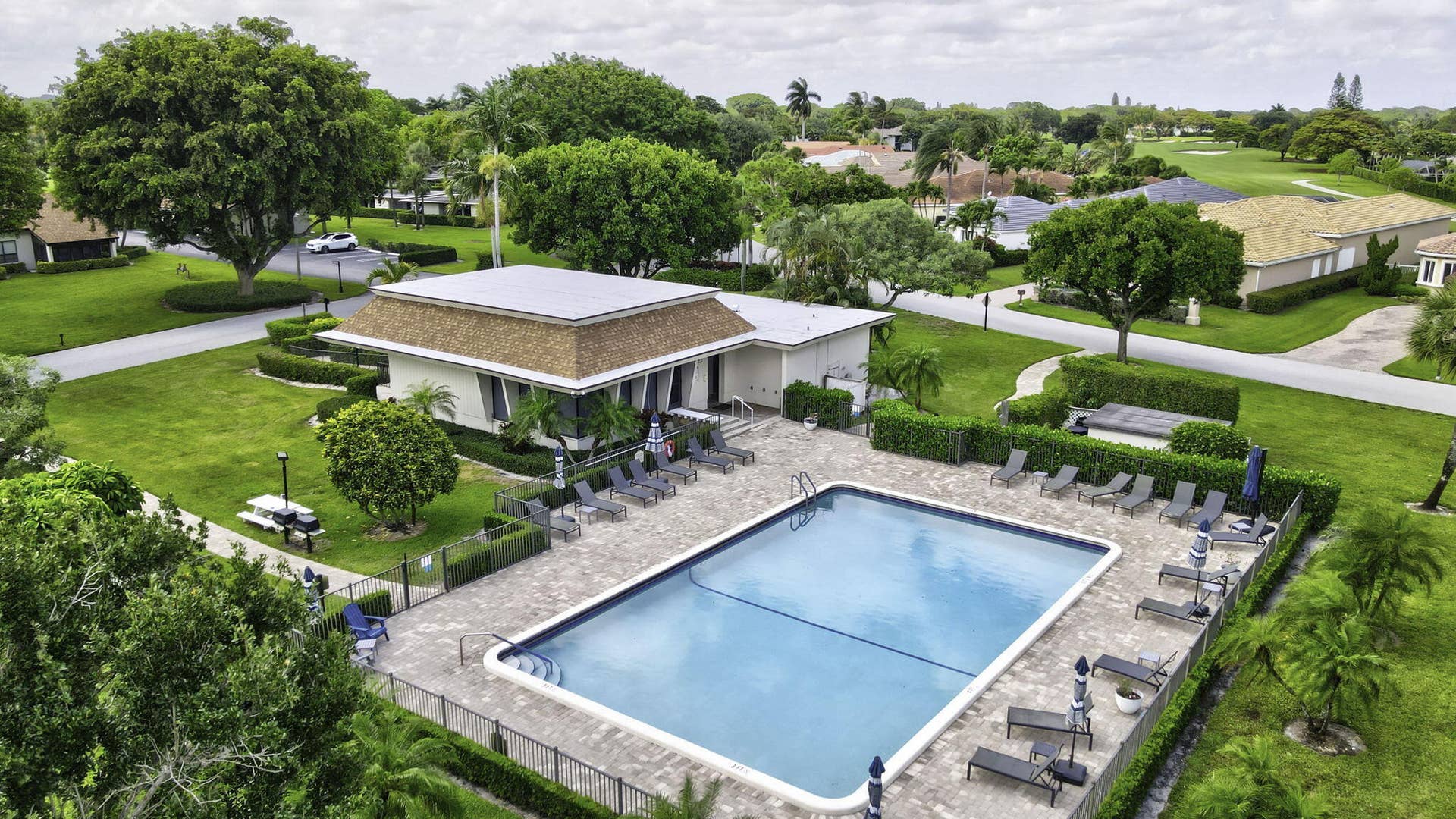 900 Greensward Lane, #209-G, Delray Beach, FL 33445 Rectangular swimming pool with paved surround, surrounded by a black metal fence