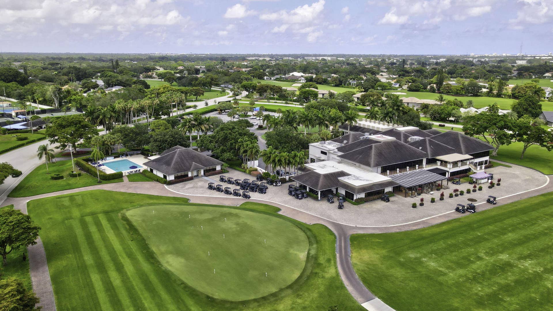 900 Greensward Lane, #209-G, Delray Beach, FL 33445 Expansive golf course with manicured greens, clubhouse building, large swimming pool, and mature landscaping