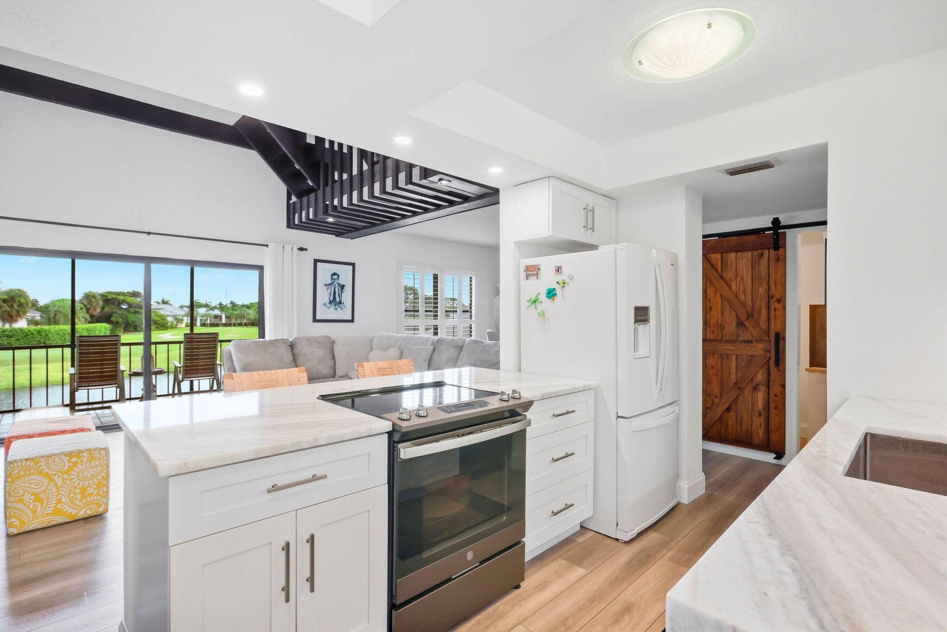 900 Greensward Lane, #209-G, Delray Beach, FL 33445 Kitchen with white cabinetry, light countertops, integrated stainless steel range, and wood-finish flooring