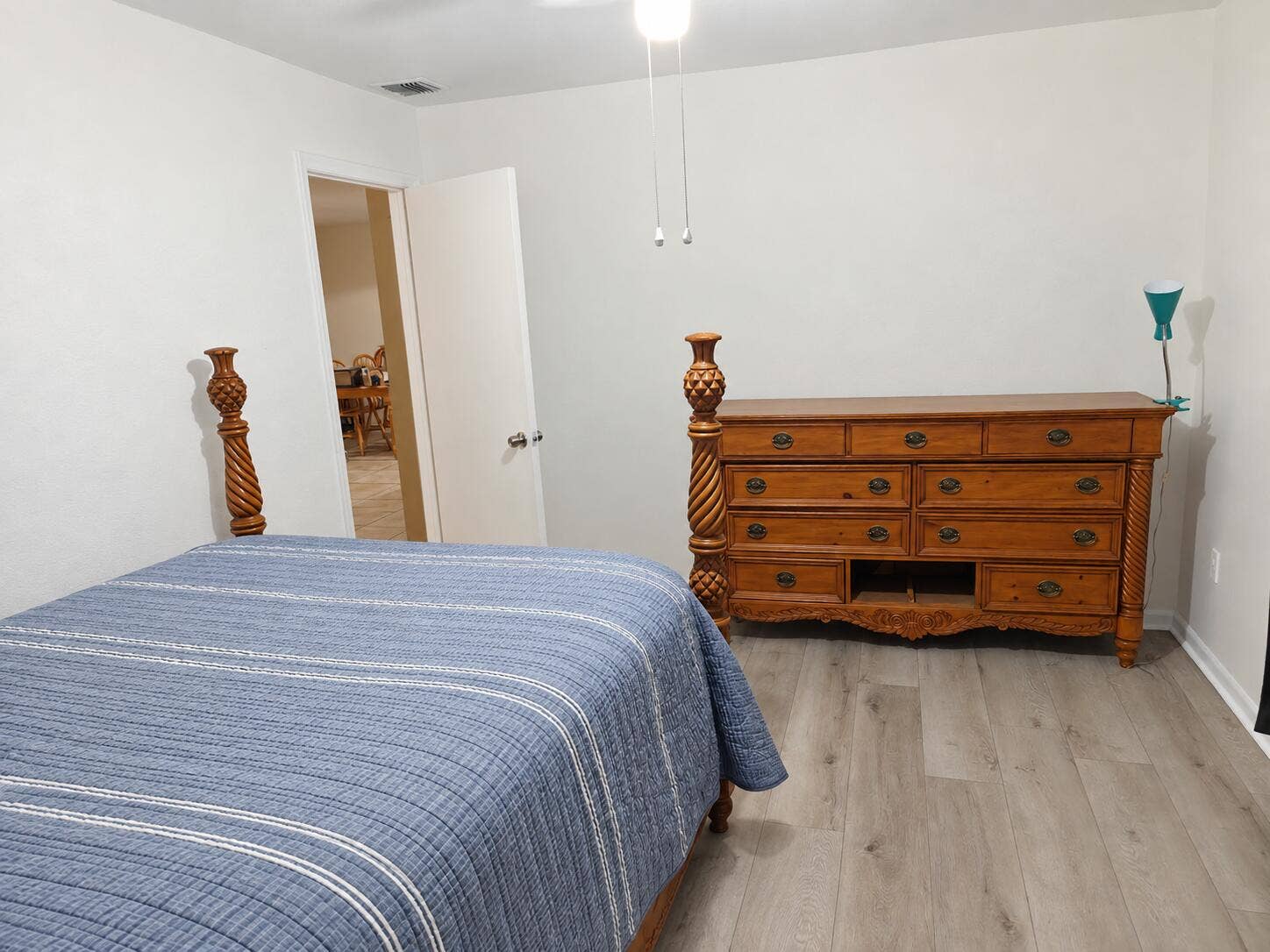 Neutral wall color throughout, wood-finish flooring, and a ceiling-mounted light fixture