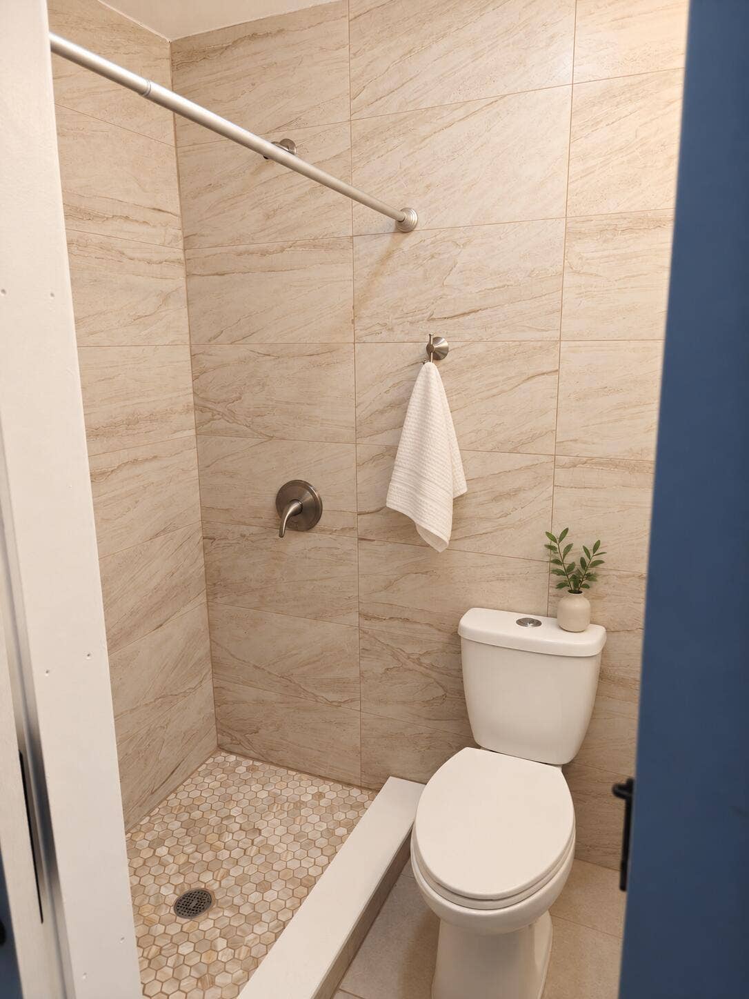 Shower stall with full-height tile surround and pebble-tile flooring