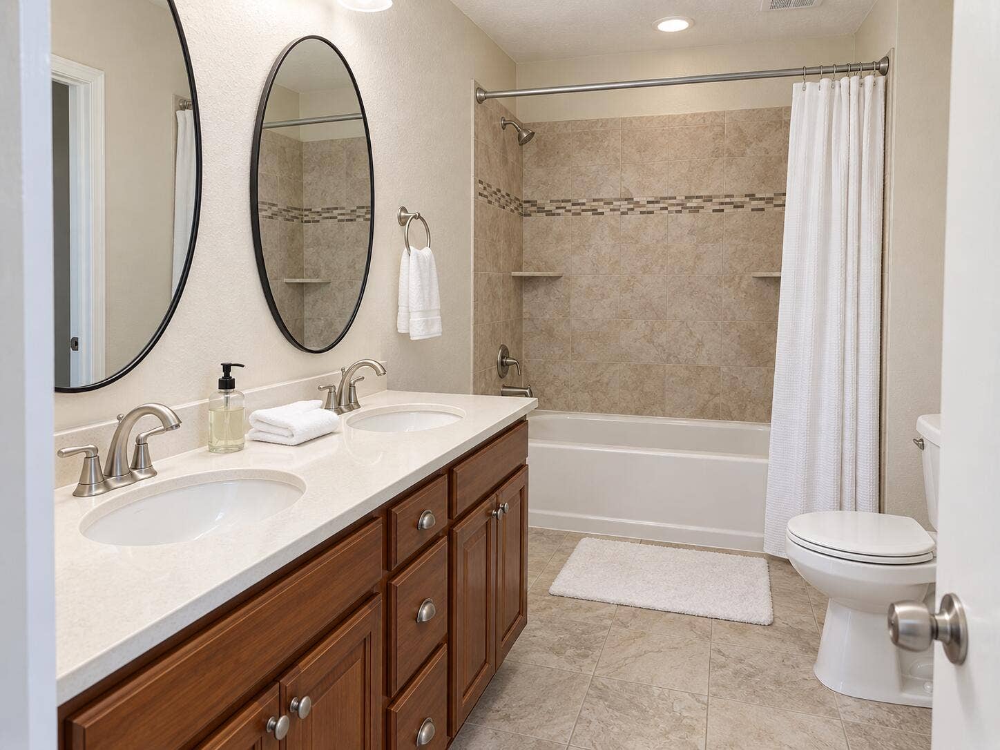 Double vanity with integrated sinks, brushed nickel fixtures, and wood-finish cabinetry