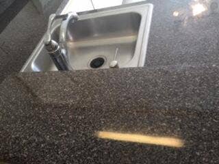 149 MOCCASIN Trail S, Jupiter, FL 33458 Stainless steel sink with a high-arc faucet set into a dark speckled countertop