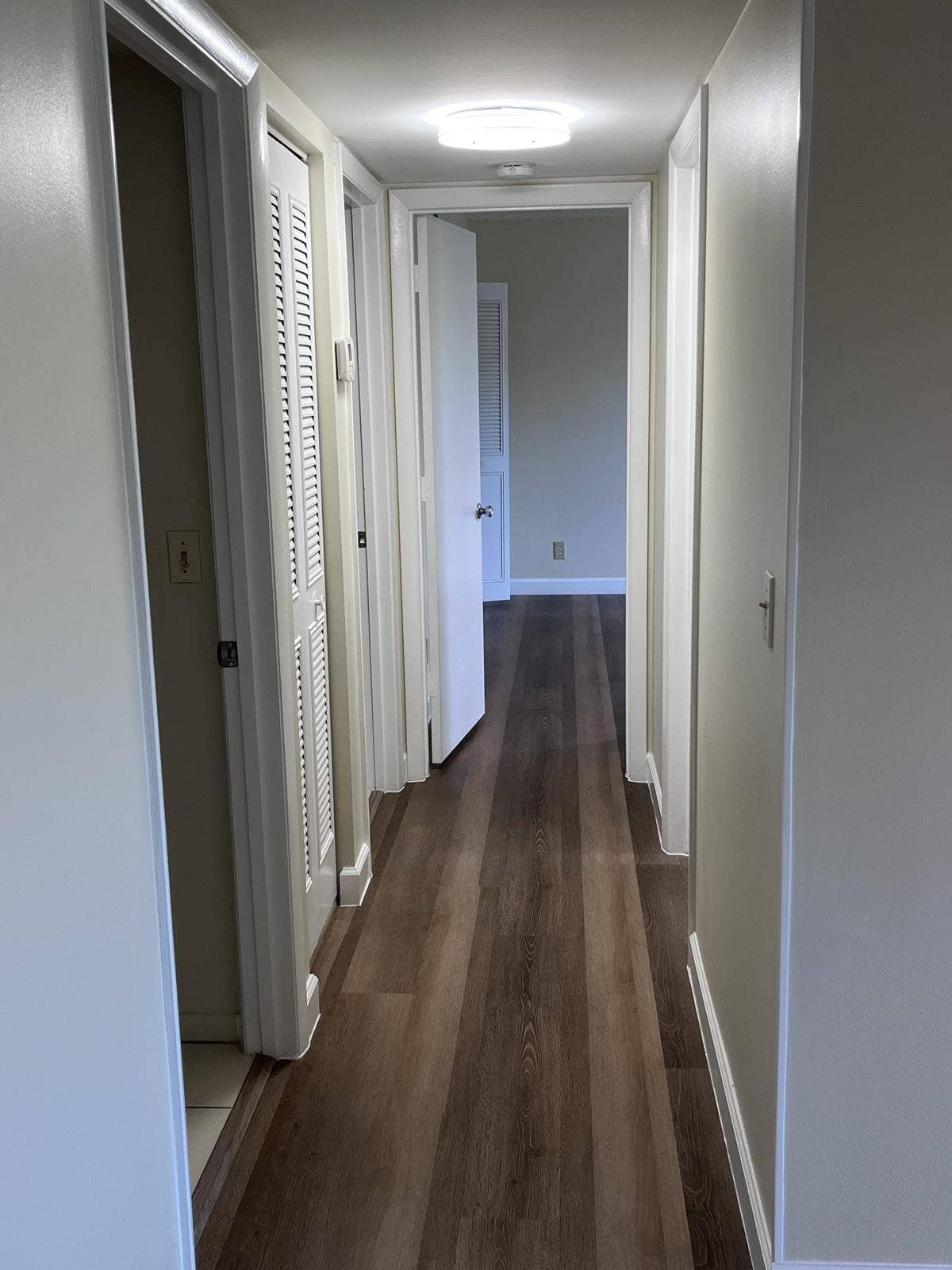 1002 Green Pine Boulevard, #F2, West Palm Beach, FL 33409 Hallway with wood-finish flooring, recessed lighting, and white paneled doors