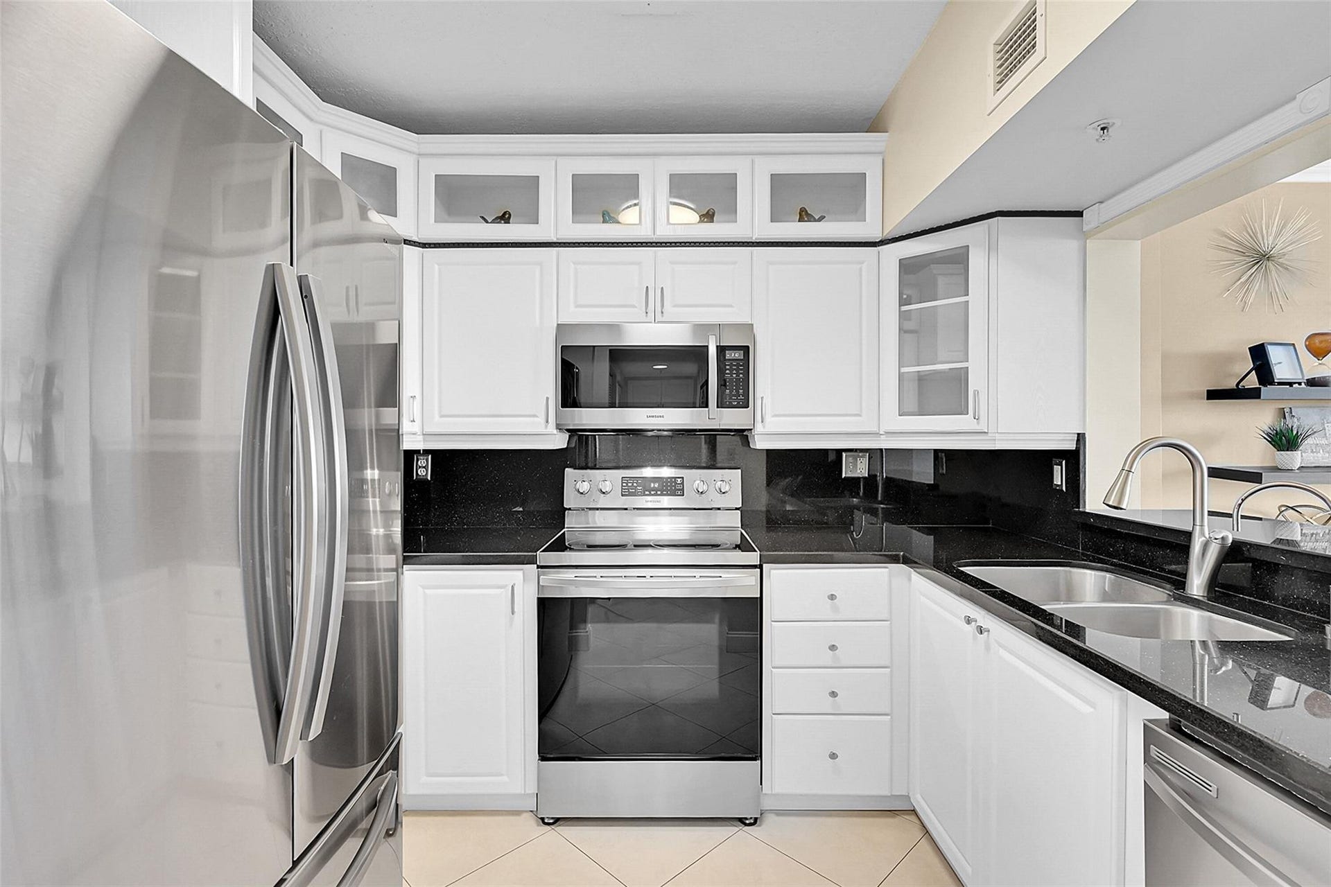 3020 NE 32ND Avenue, #805, Fort Lauderdale, FL 33308 Bright kitchen featuring white cabinetry, stainless steel appliances, and a functional layout for everyday living.