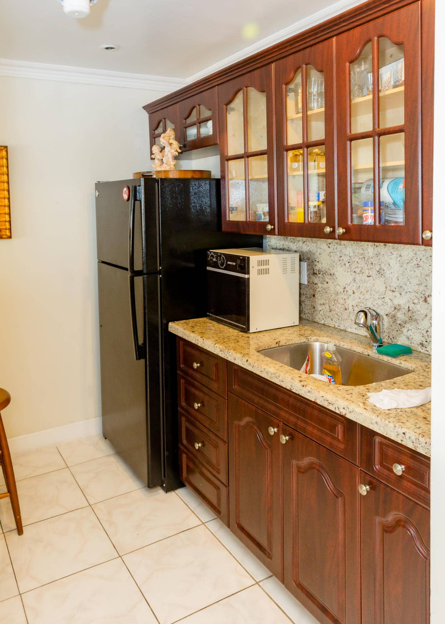 630 Layne Boulevard, #208, Hallandale Beach, Hallandale Beach, FL 33009 Recessed stainless steel sink with a single-handle faucet, stone countertop, wood-finish cabinetry, and tiled flooring