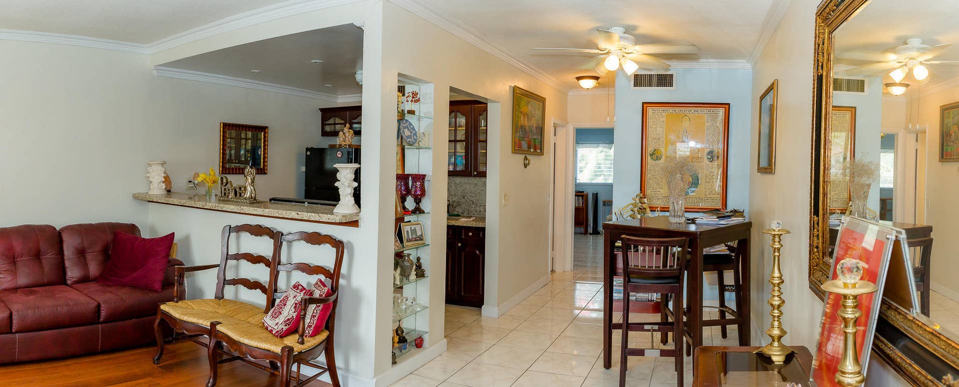 630 Layne Boulevard, #208, Hallandale Beach, Hallandale Beach, FL 33009 Open concept living space featuring a breakfast bar with a solid surface countertop, warm wood-finish flooring, and crown molding
