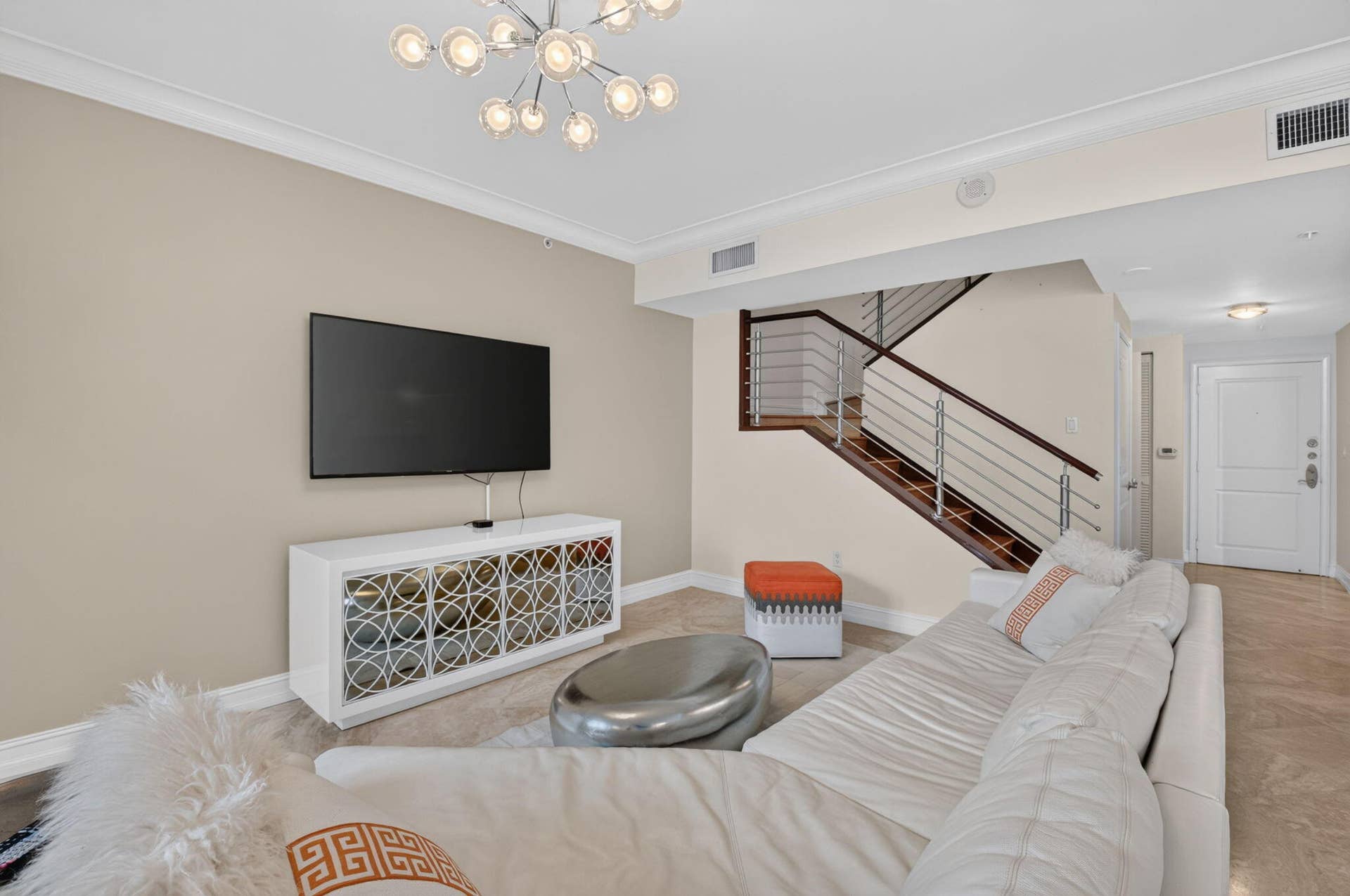 99 SE Mizner Boulevard, #Ph37, Boca Raton, FL 33432 Contemporary lighting, crown molding, and wood-finish staircase with metal railings.