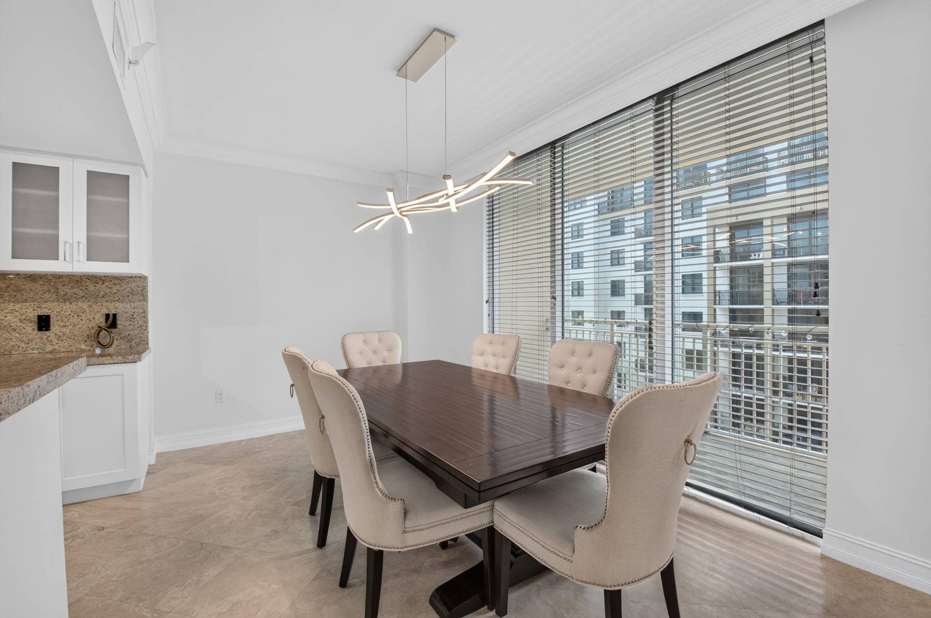 99 SE Mizner Boulevard, #Ph37, Boca Raton, FL 33432 Contemporary chandelier illuminates the dining area with a view.