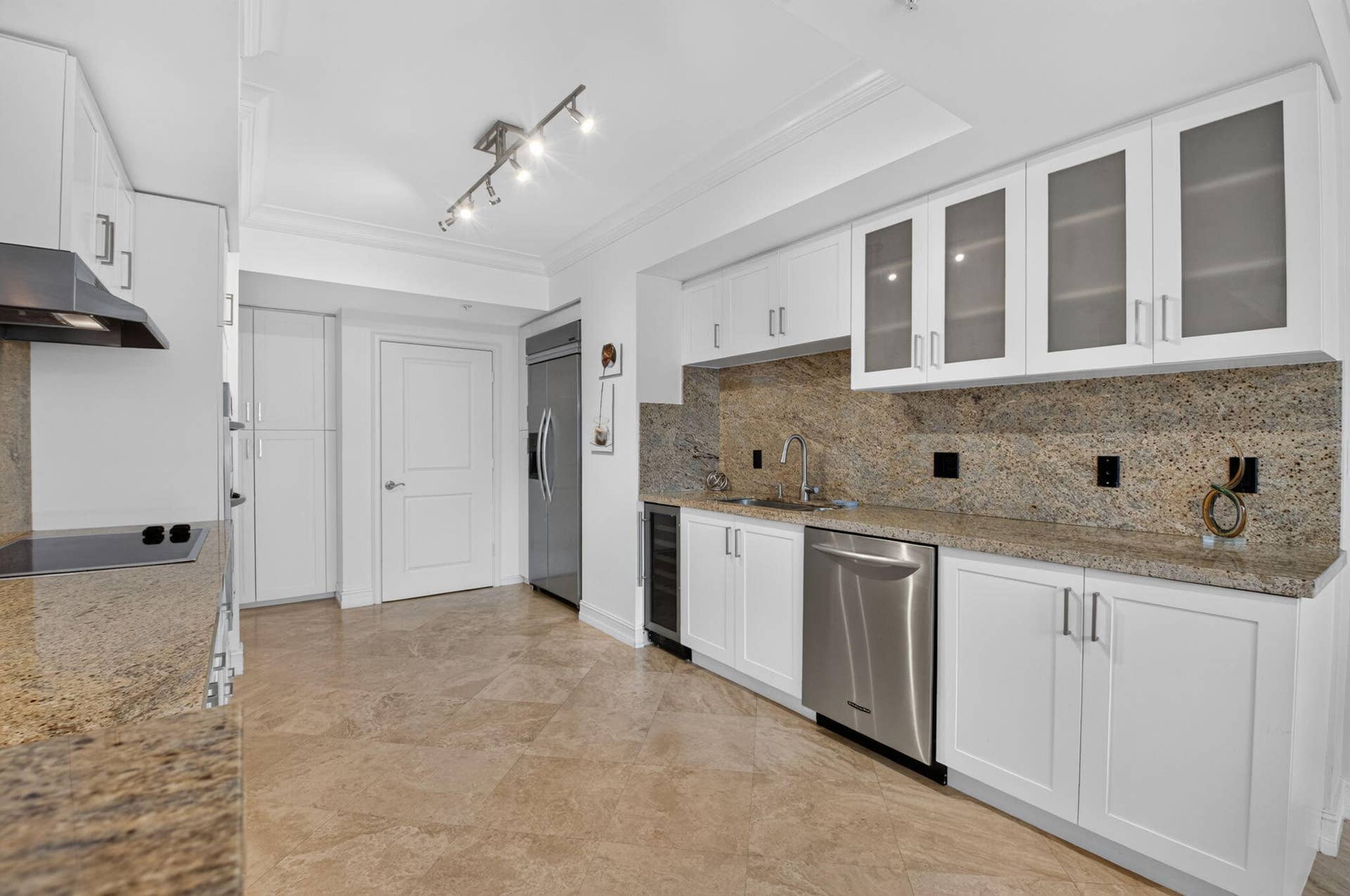 99 SE Mizner Boulevard, #Ph37, Boca Raton, FL 33432 White cabinetry with frosted glass accents, stainless steel appliances, a built-in wine refrigerator, and tile flooring