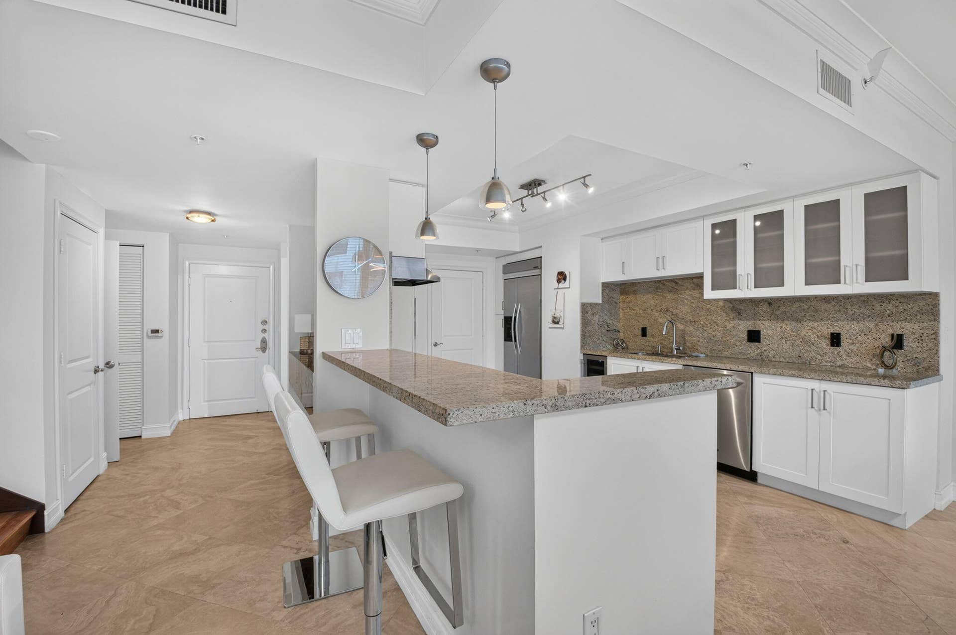 99 SE Mizner Boulevard, #Ph37, Boca Raton, FL 33432 Kitchen featuring granite countertops, stainless steel appliances, white cabinetry with frosted glass, and pendant lighting.