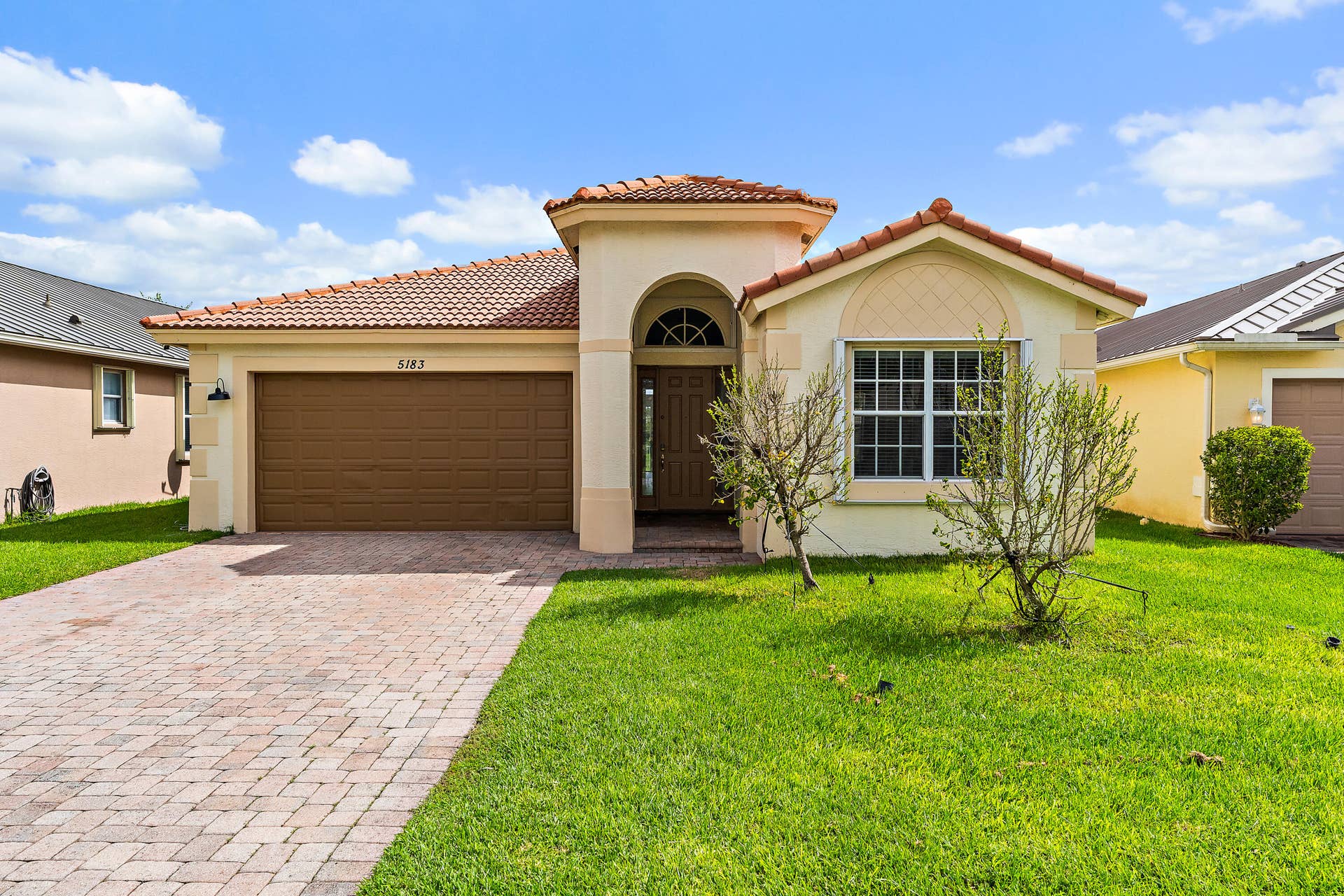 5183 SE Graham Drive, Stuart, FL 34997 Welcome home to this Mediterranean-style home with classic Florida curb appeal: a barrel tile roof, an arched entry, and a wide paver driveway leading to a two-car garage. The lush green lawn and fresh landscaping make a great first impression, and accordion shutters on the windows mean storm prep takes minutes. Behind the front door, the views open to the pond and preserve.